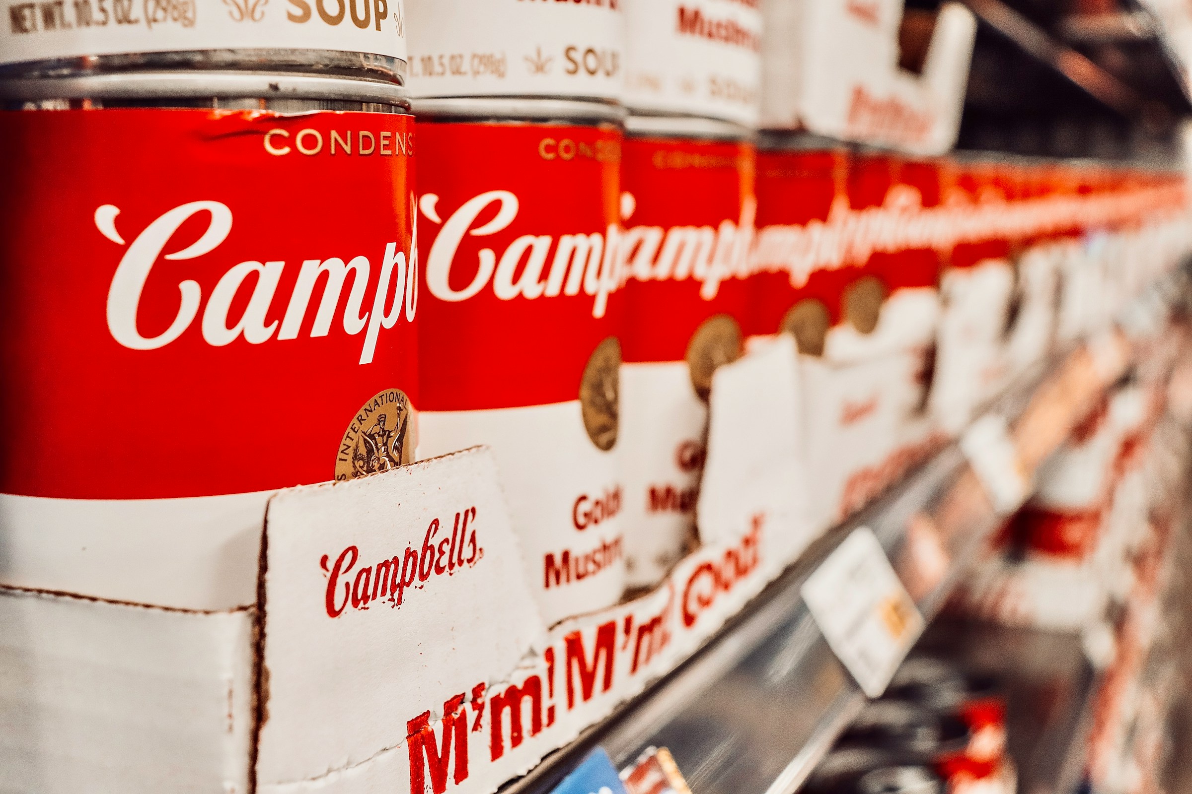 Boîtes de soupe empilées sur une étagère de supermarché | Source : Unsplash