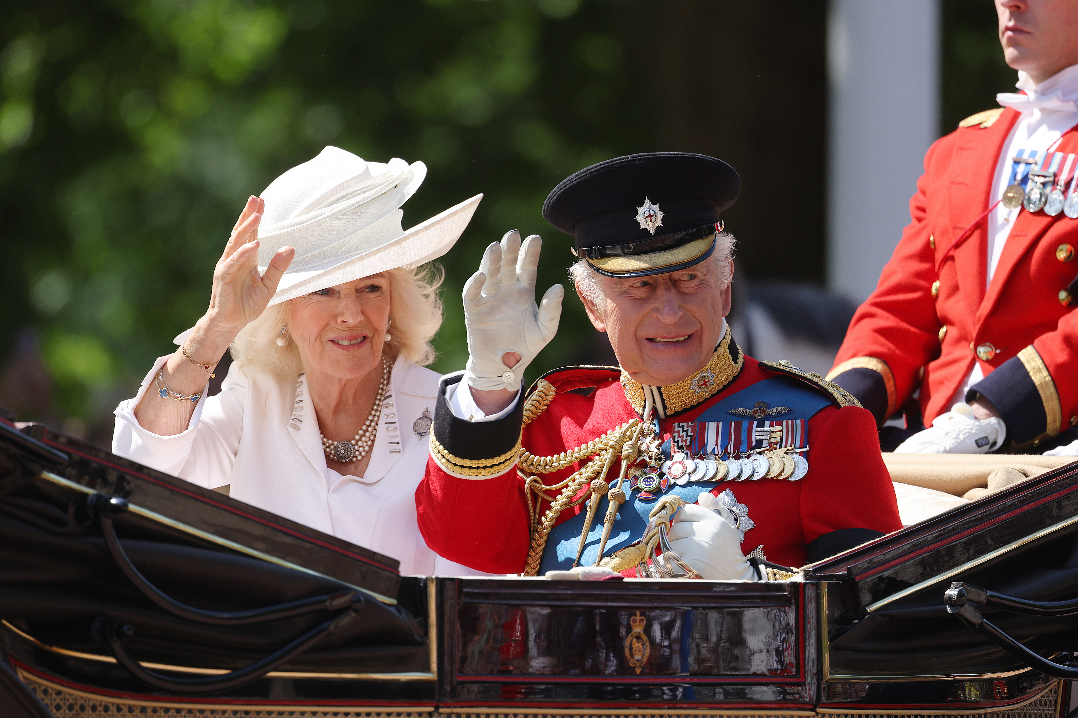 La reine Camilla et le roi Charles III dans leur carrosse et saluant les badauds lors de la montée des couleurs. | Source : Getty Images