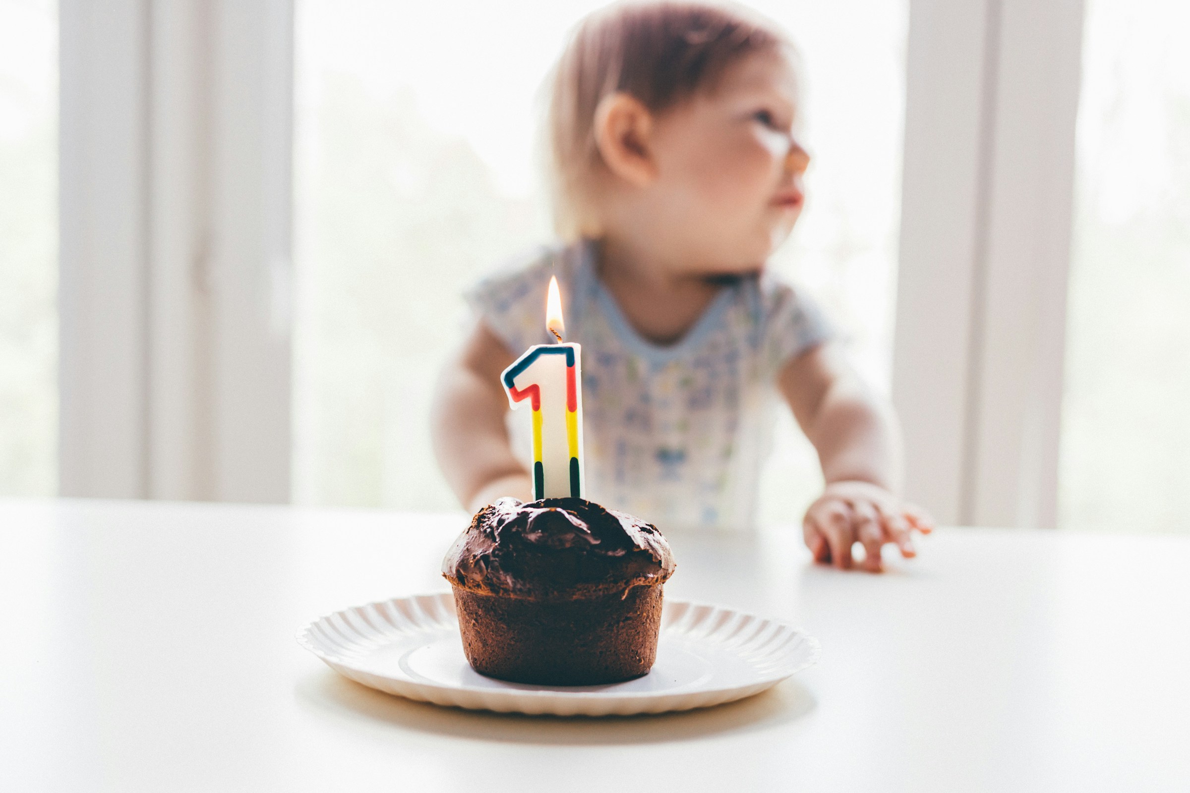 Un petit gâteau avec une bougie assis devant un bébé | Source : Unsplash