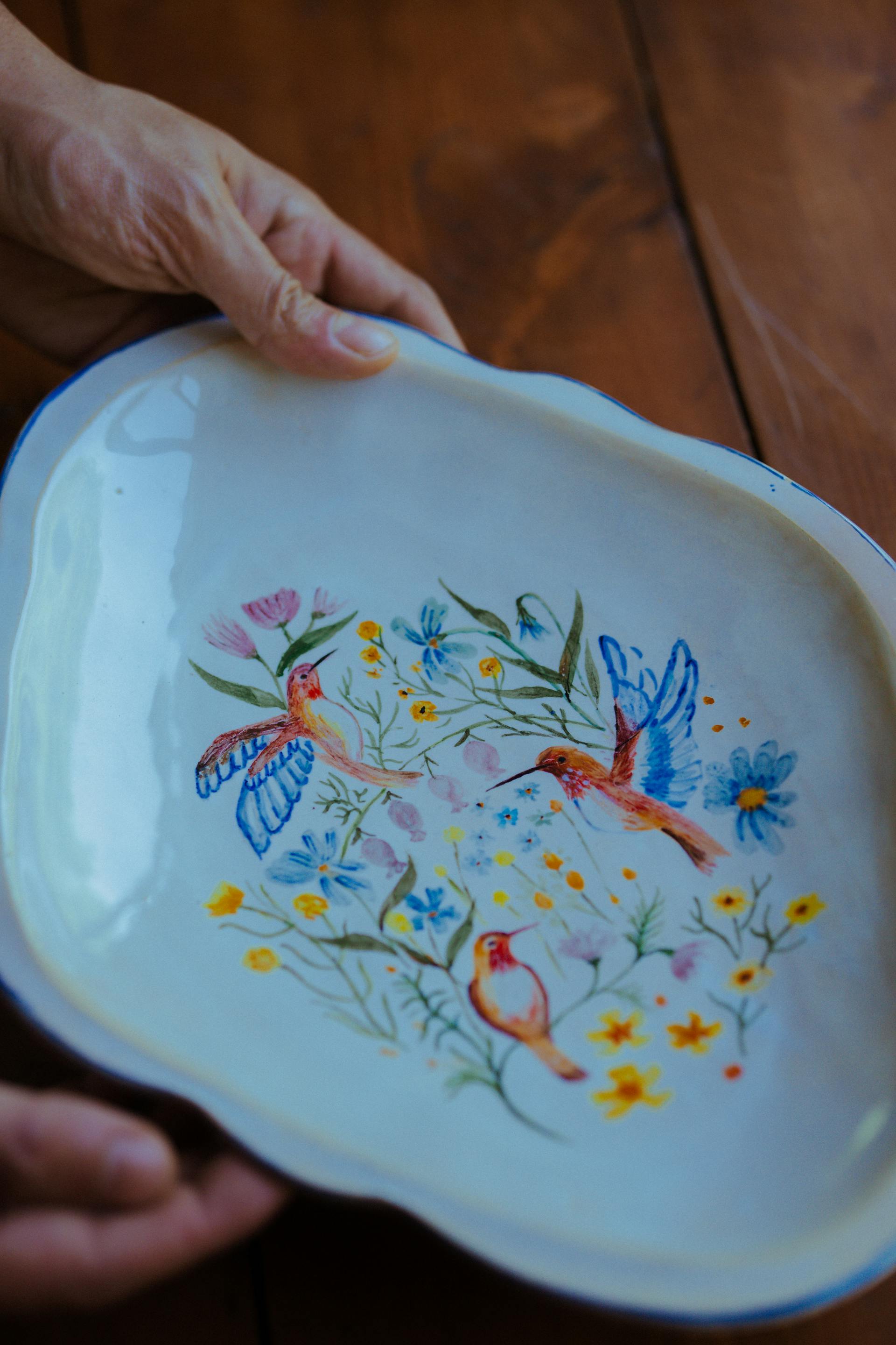 Une femme tenant un plat en céramique peint à la main | Source : Pexels