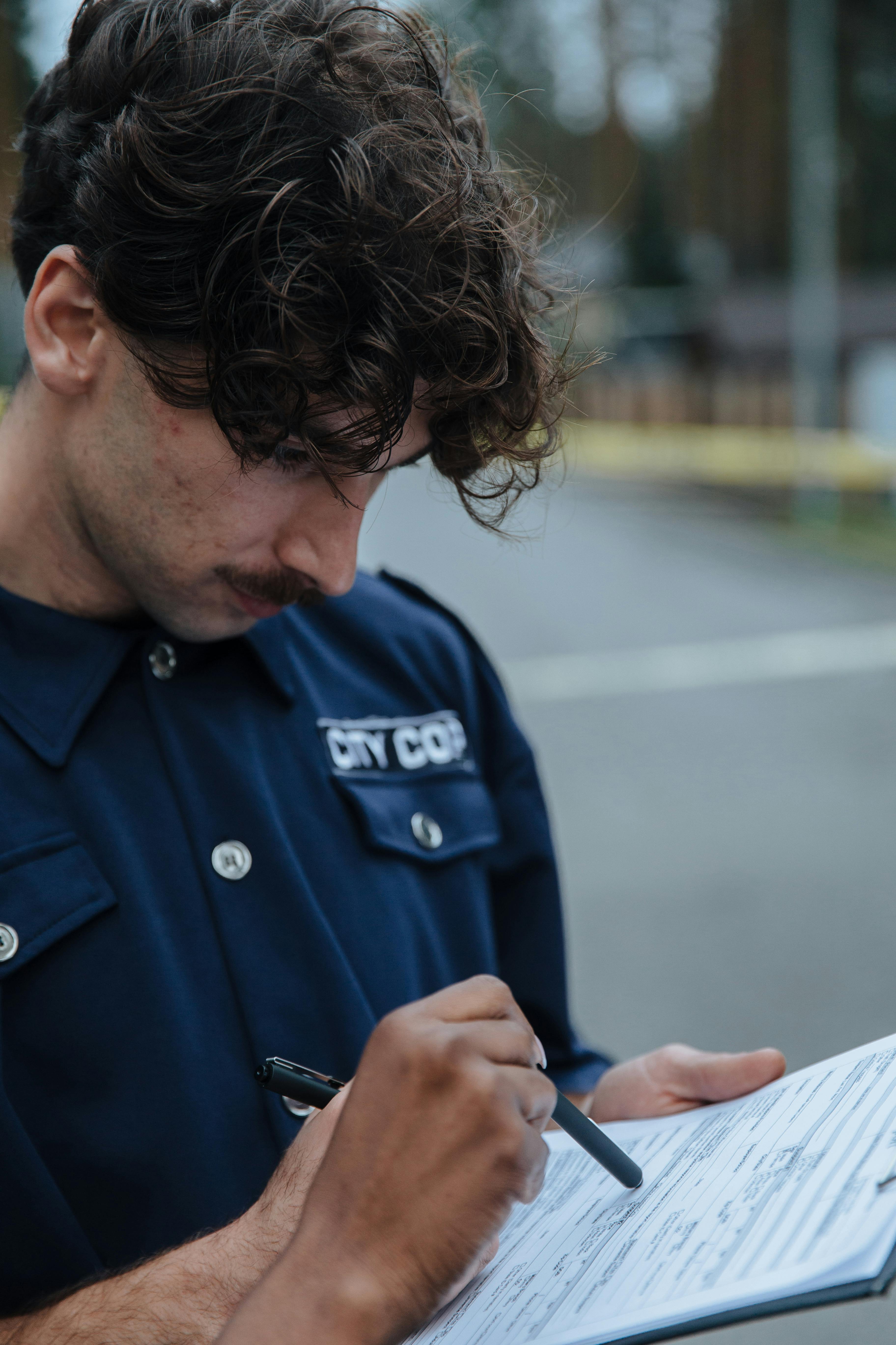 Un agent de police regarde un document | Source : Pexels