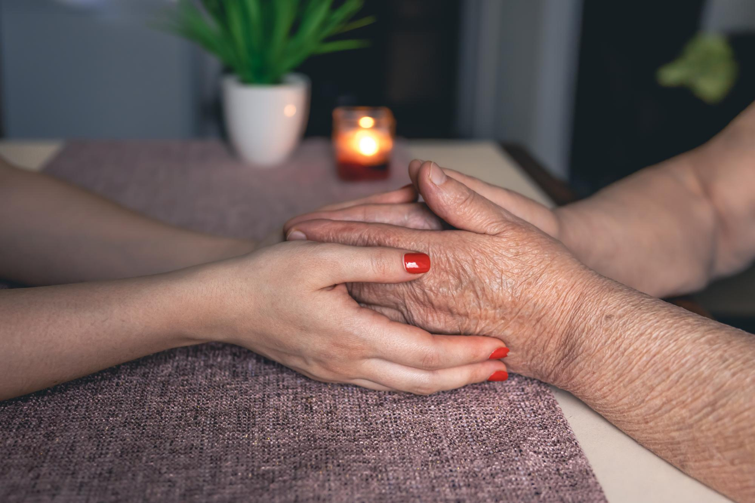 Une jeune femme tenant les mains d'une personne âgée | Source : Freepik