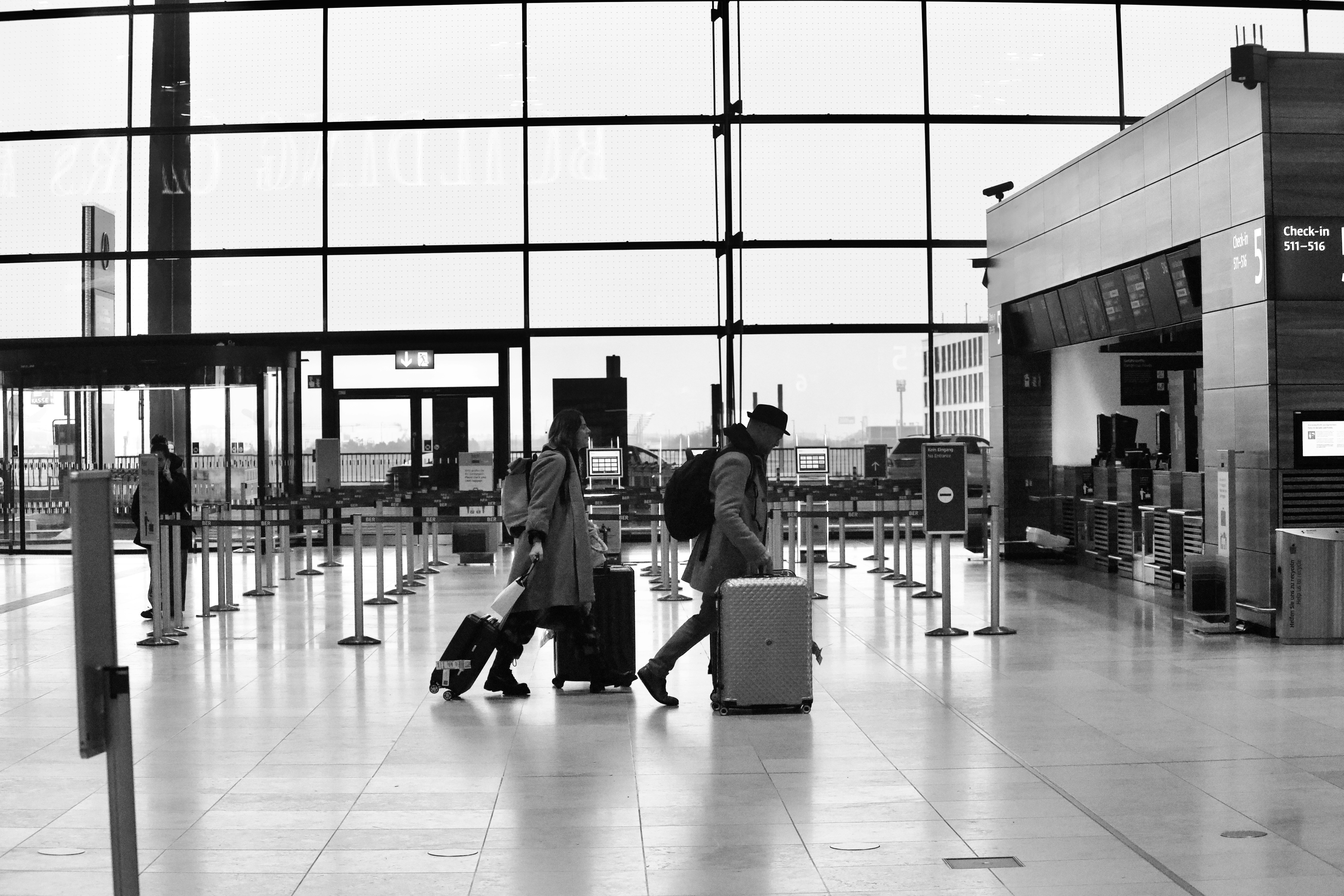 Un couple tirant ses bagages dans un terminal d'aéroport | Source : Unsplash