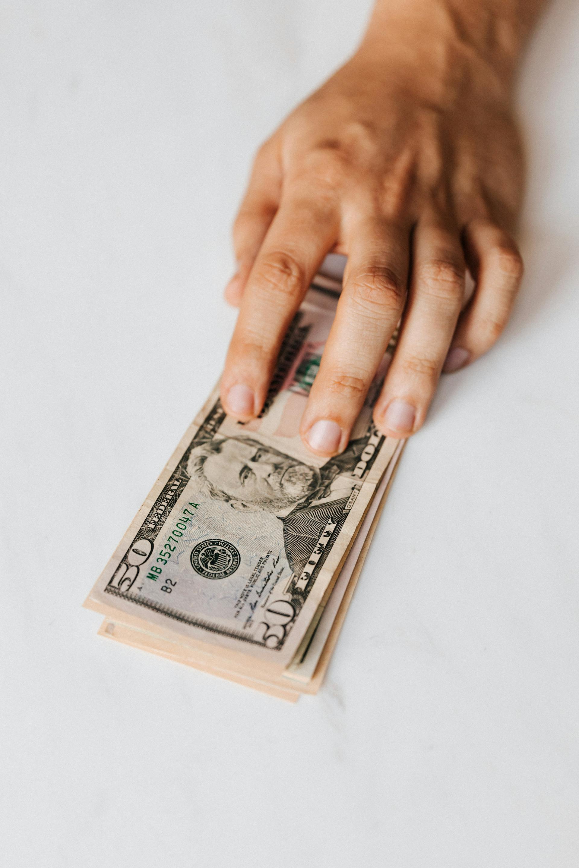 Un homme tenant de l'argent | Source : Pexels
