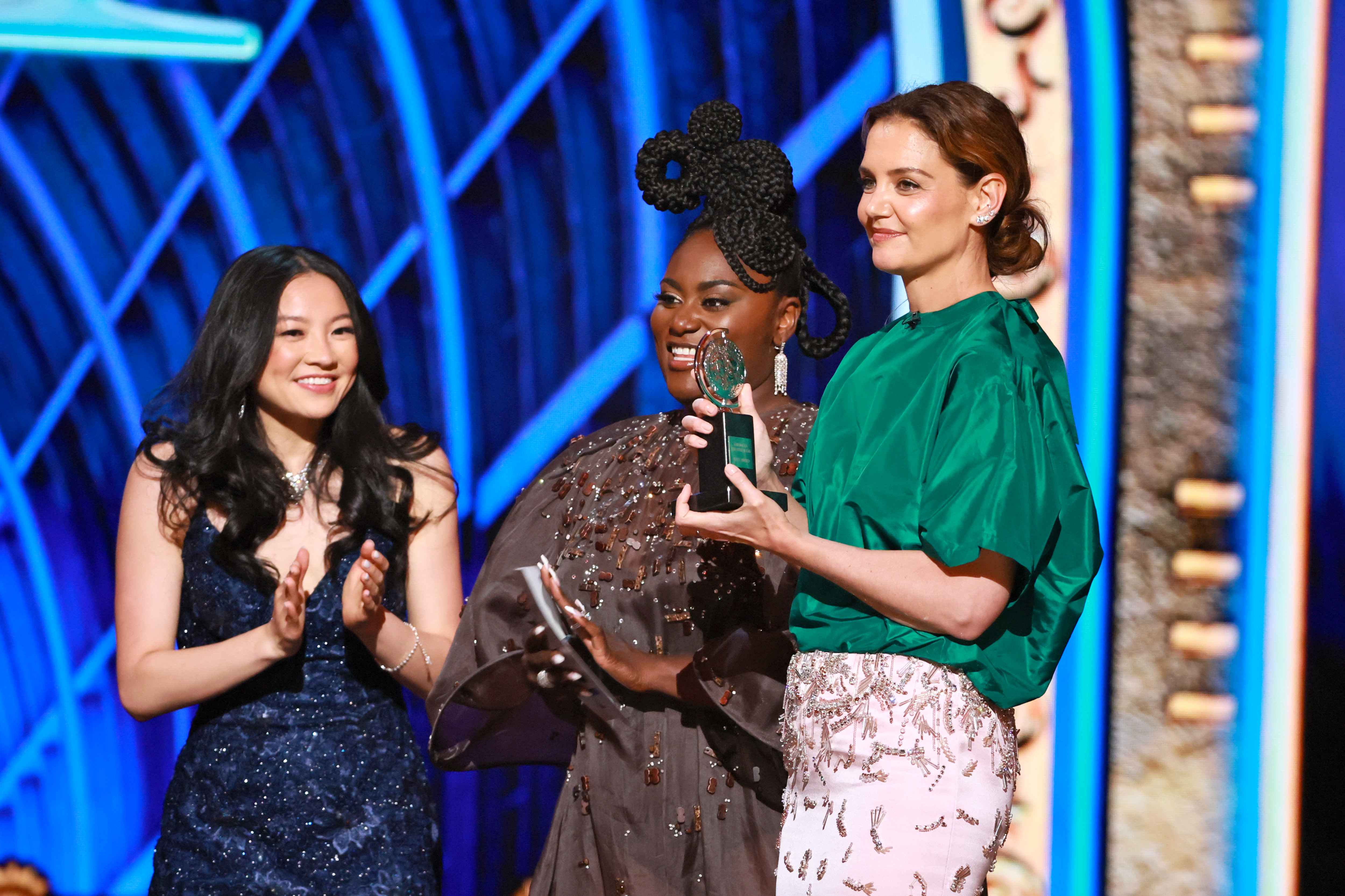 Katie Holmes rejoint Danielle Brooks et un lauréat souriant sur scène, célébrant une victoire aux Tony Awards. Le moment reflète à la fois le style et la joie, avec Holmes dans son ensemble remarquable applaudissant le talent de la nuit.