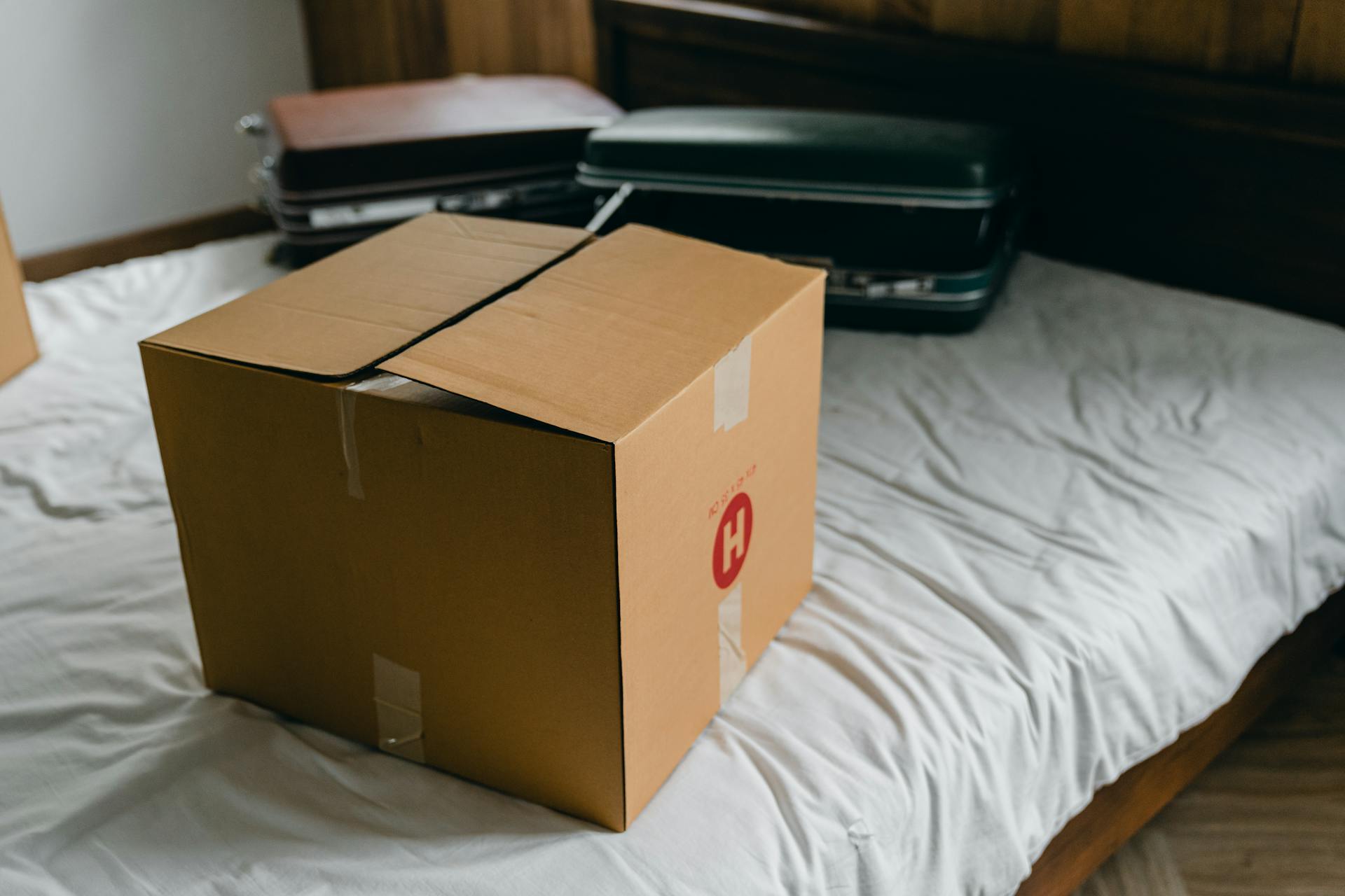 Des boîtes et des valises sur un lit | Source : Pexels