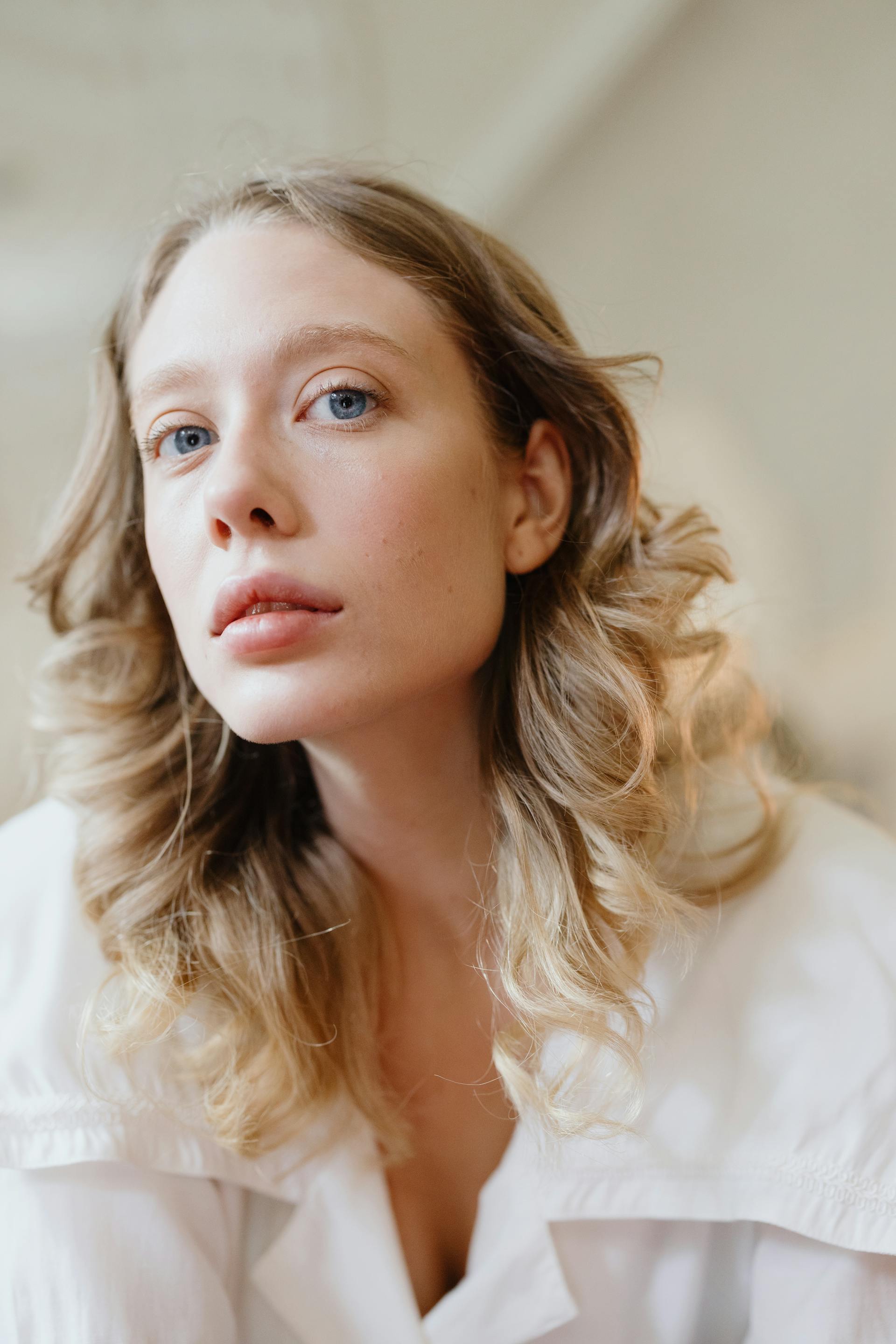 Une jeune femme blonde aux yeux bleus et aux cheveux ondulés | Source : Pexels