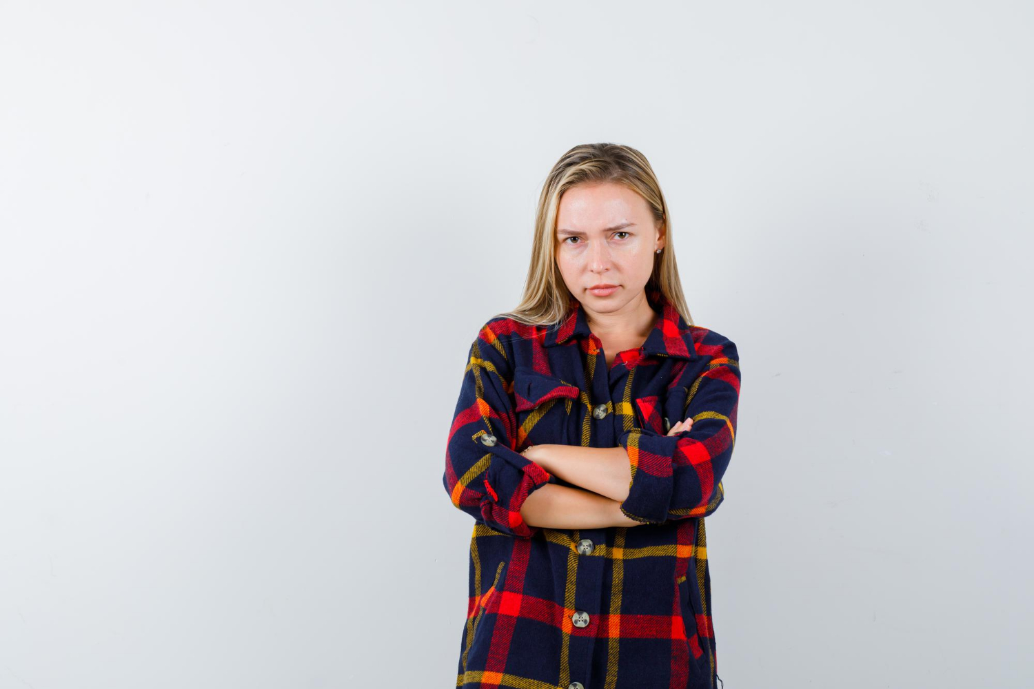 Une jeune femme agacée, les bras croisés | Source : Freepik