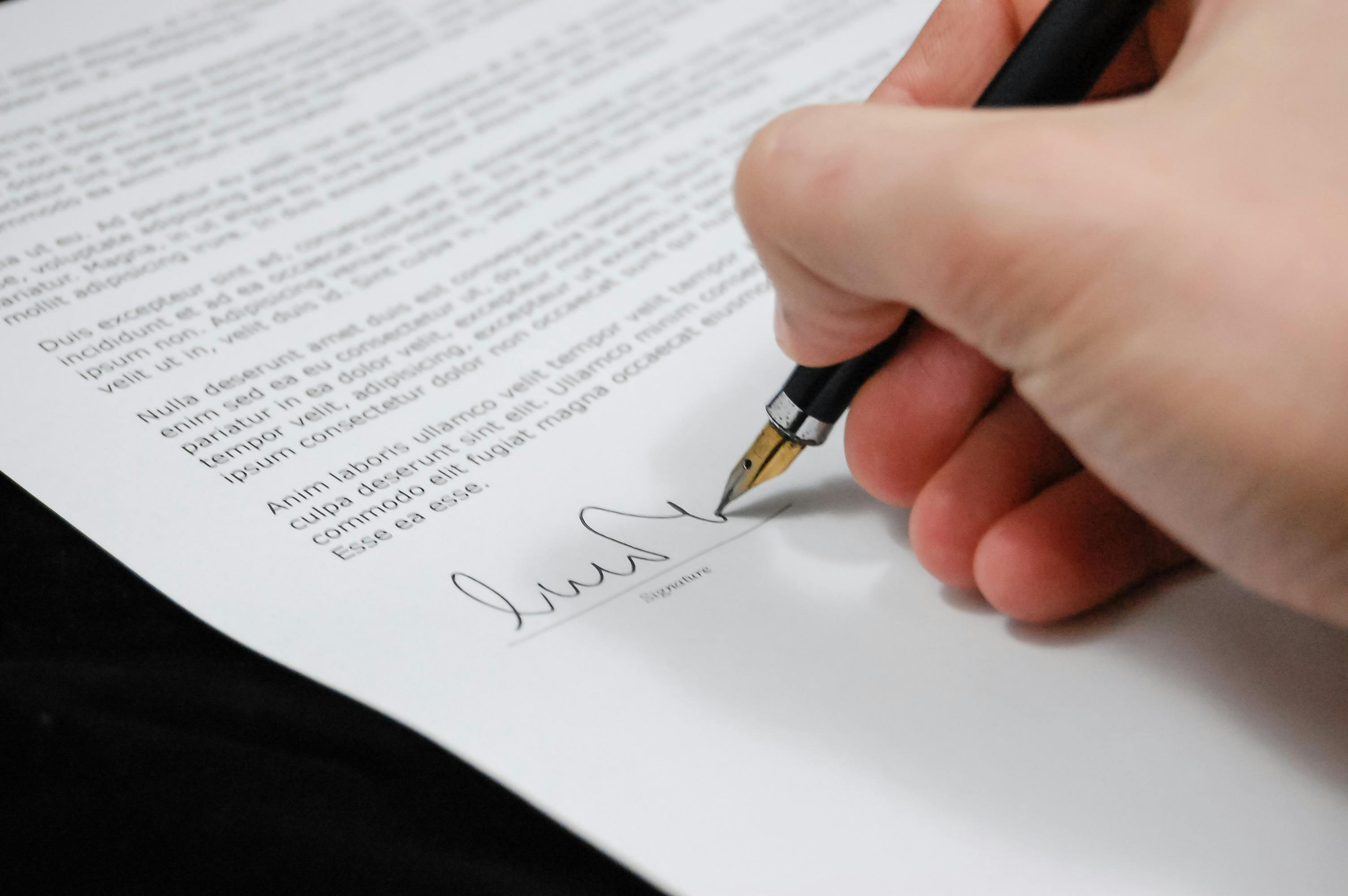 Une personne signant des documents administratifs | Source : Pexels