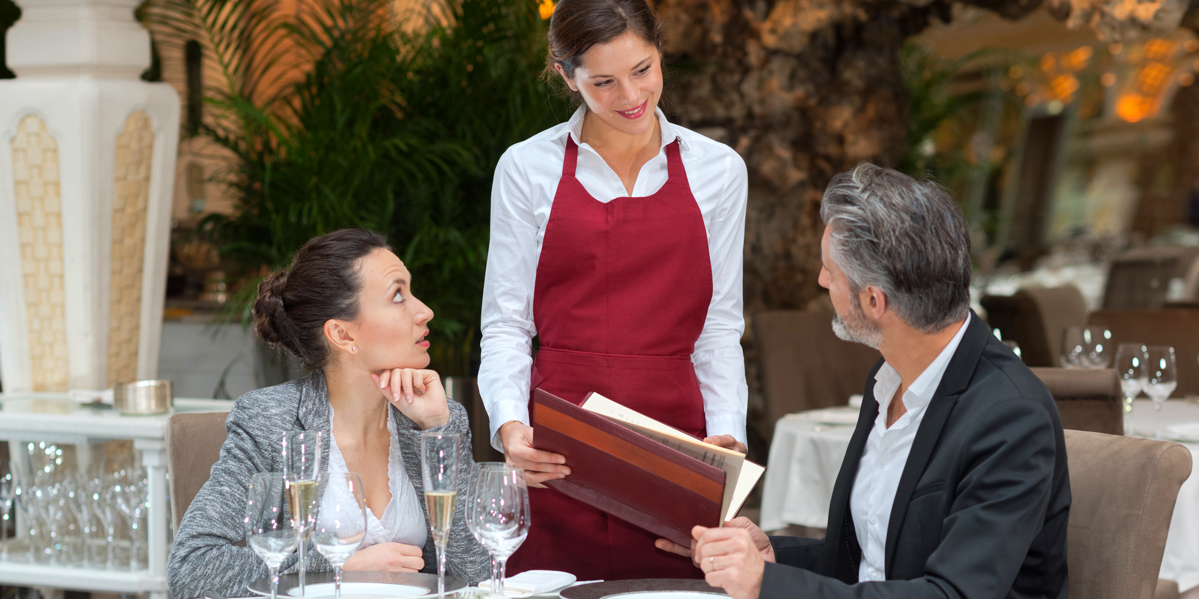 Un couple au restaurant avec une serveuse | Source : Shutterstock