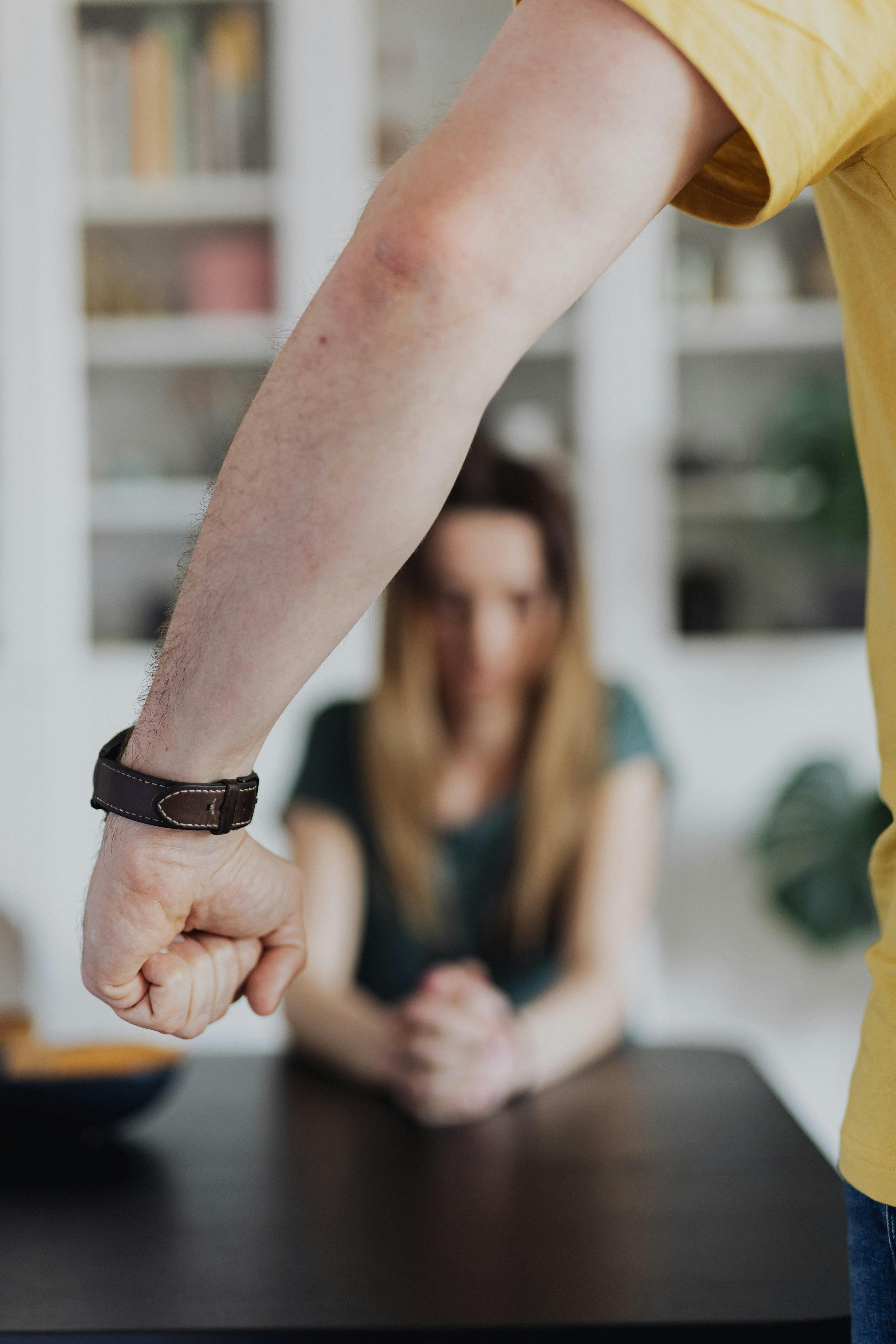 Le poing d'un homme avec une femme à l'arrière-plan | Source : Pexels