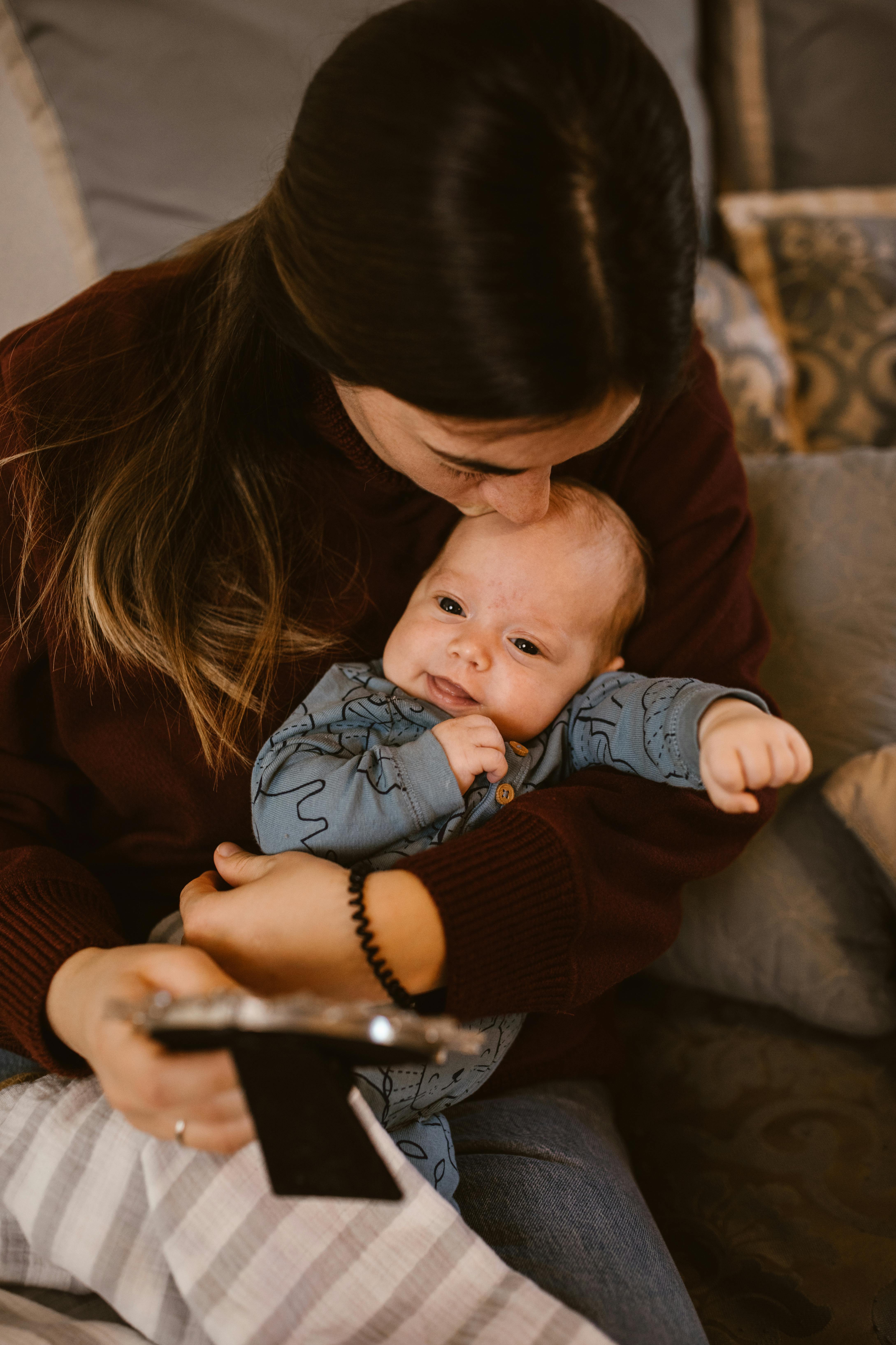A mother kissing her baby’s head | Source: Pexels