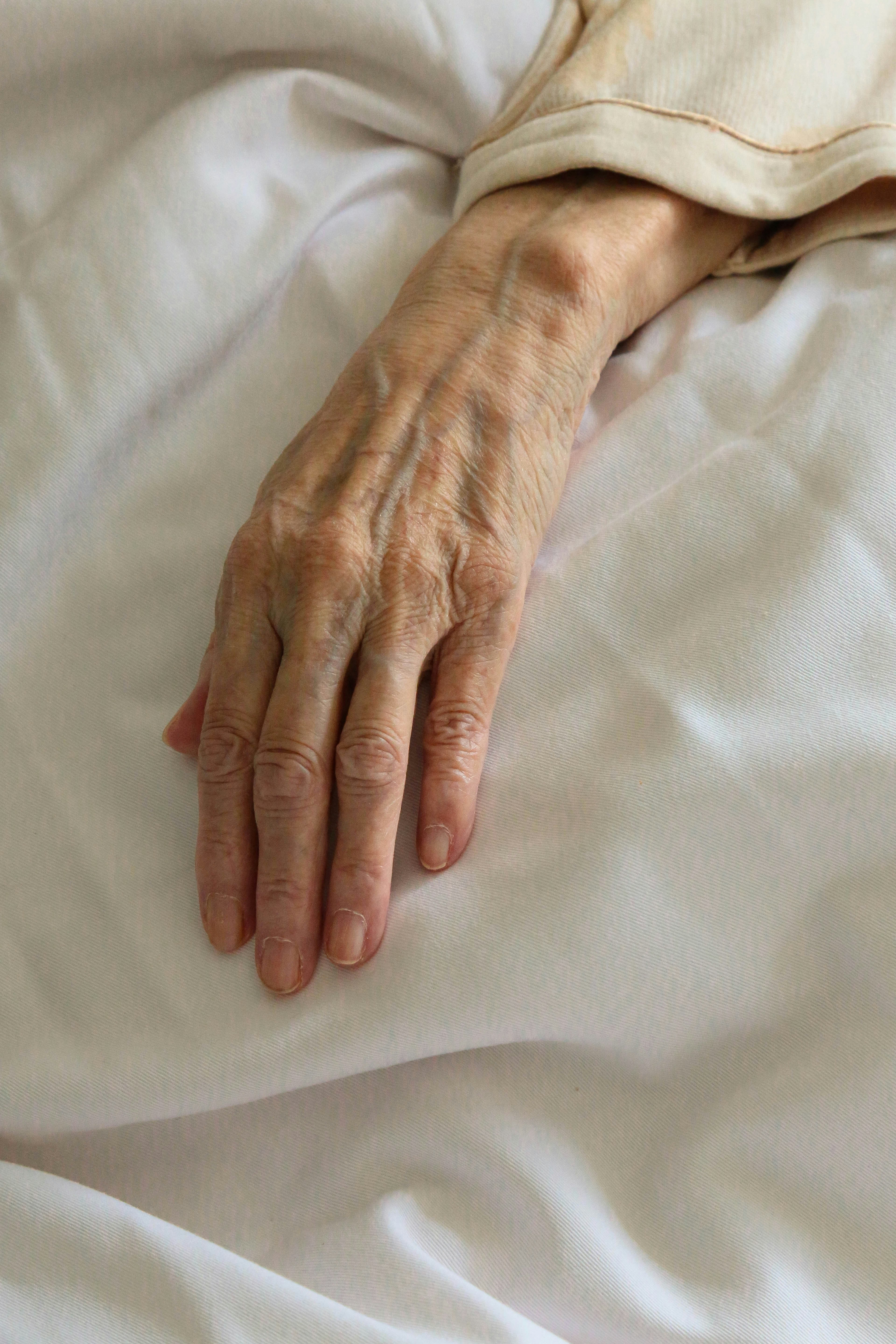 La main d'une femme malade sur un lit | Source : Unsplash