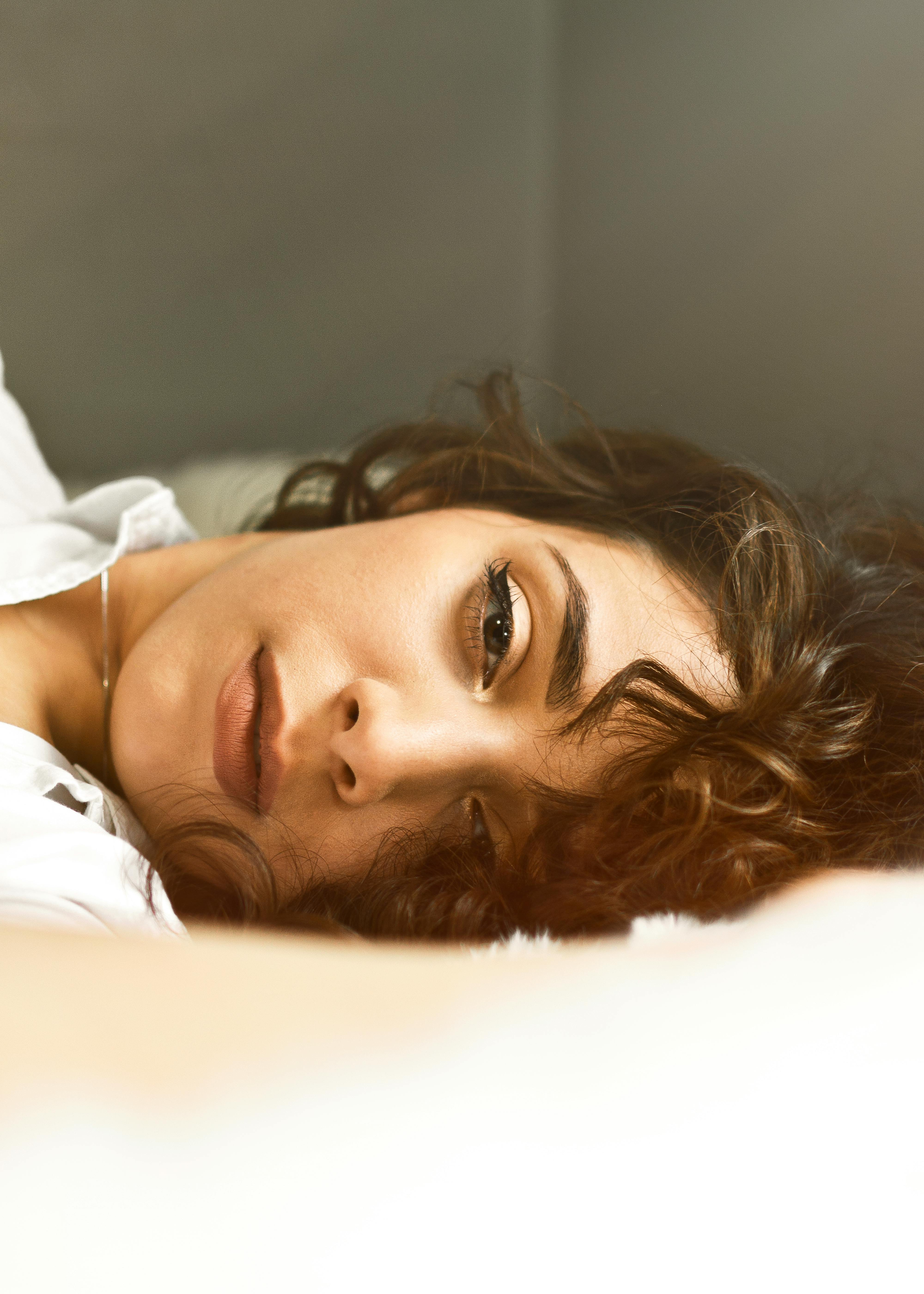 Jane dans son lit, repassant les souvenirs de Ryan dans son esprit | Source : Pexels