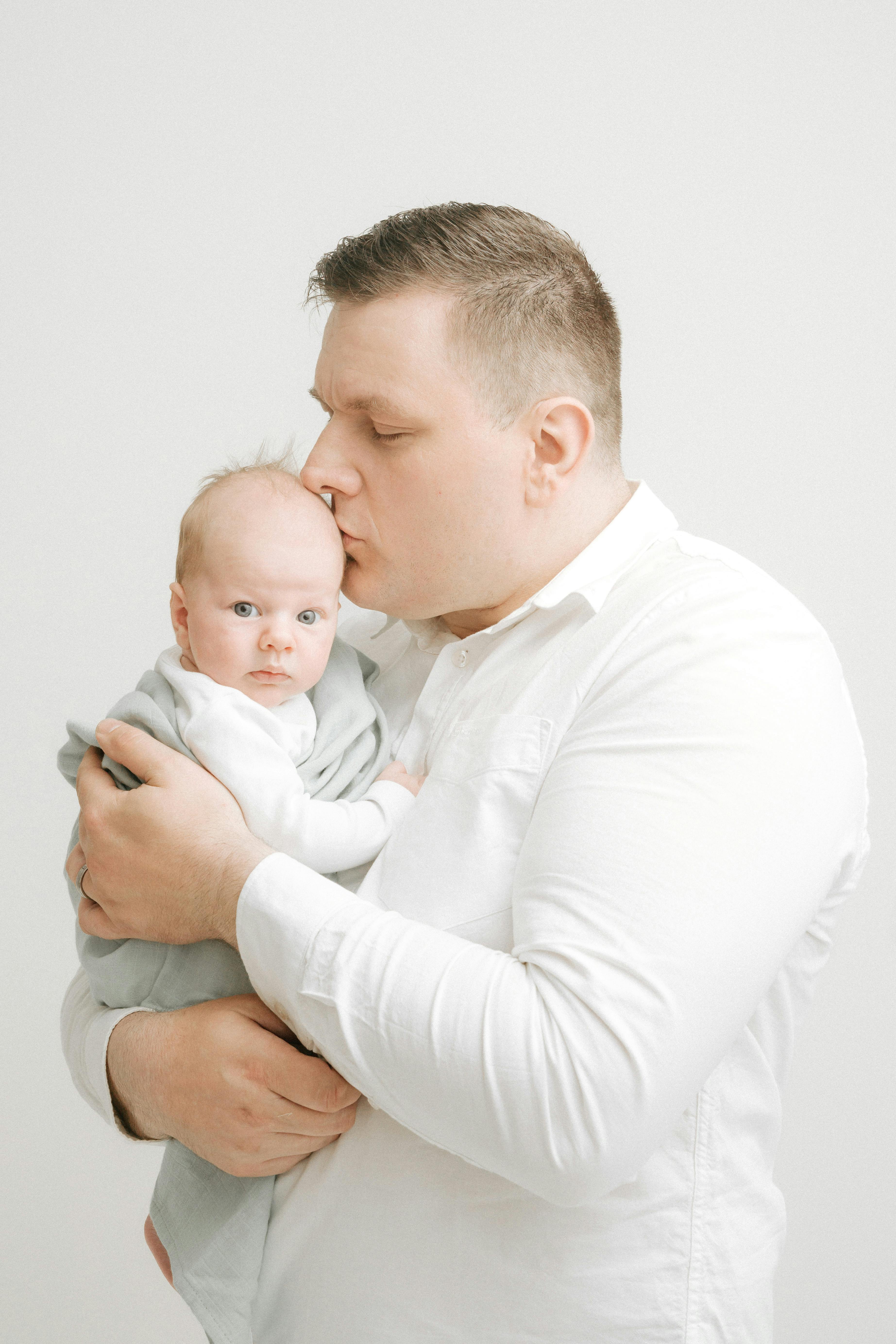 Un père embrassant la tête de son bébé | Source : Pexels