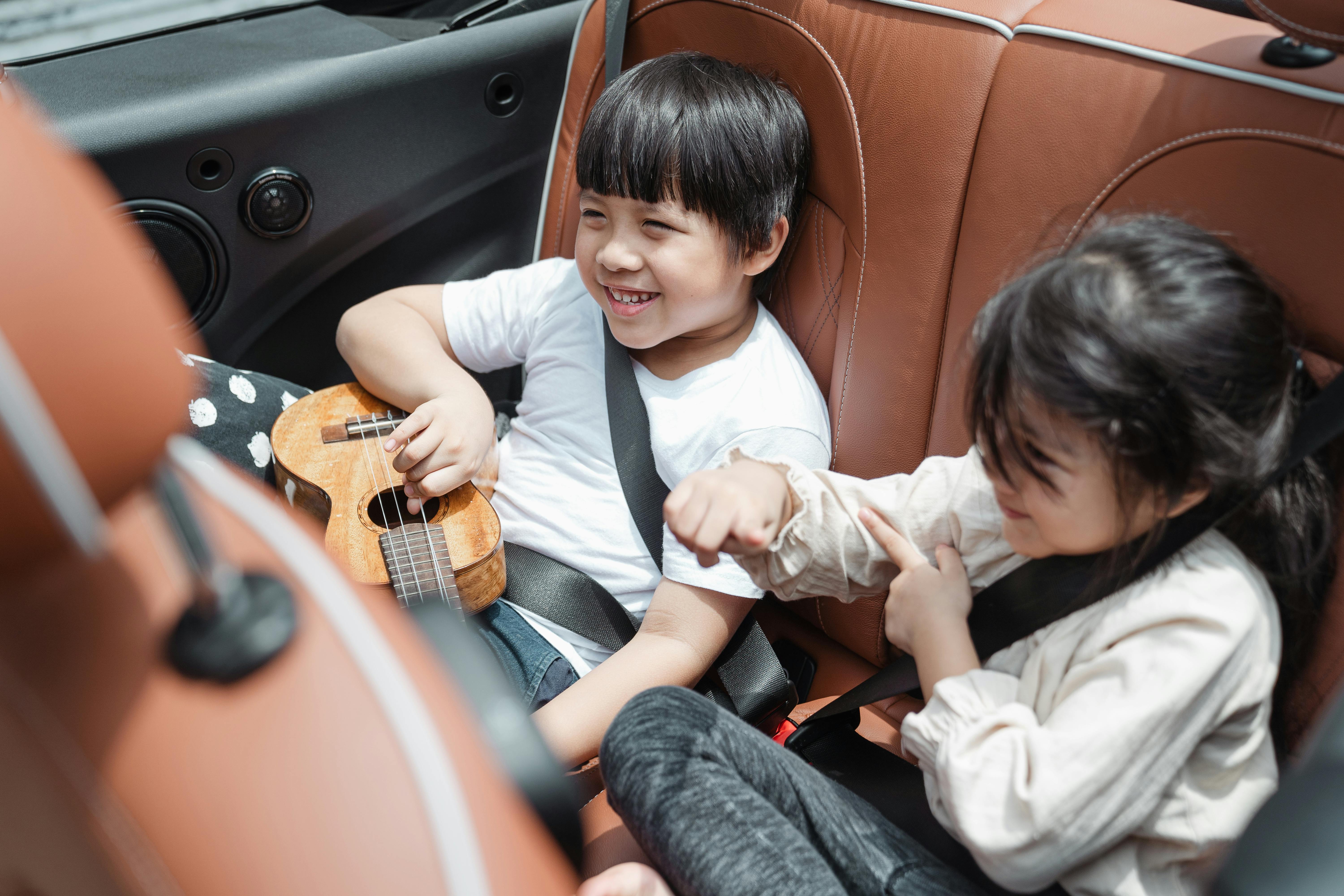 Des enfants heureux sur la banquette arrière d'une voiture | Source : Pexels