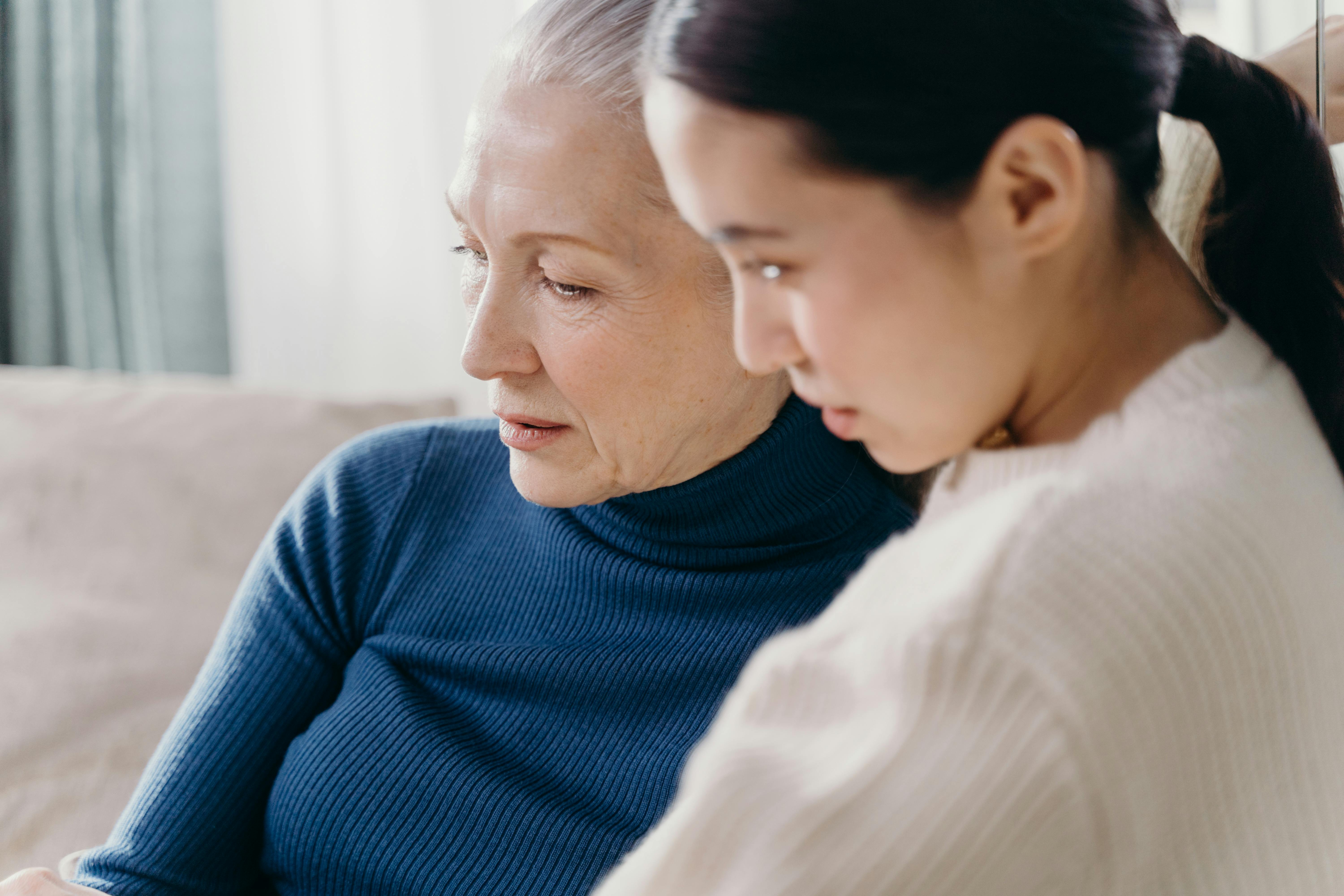 Une femme âgée et une femme plus jeune assises sur le canapé | Source : Pexels