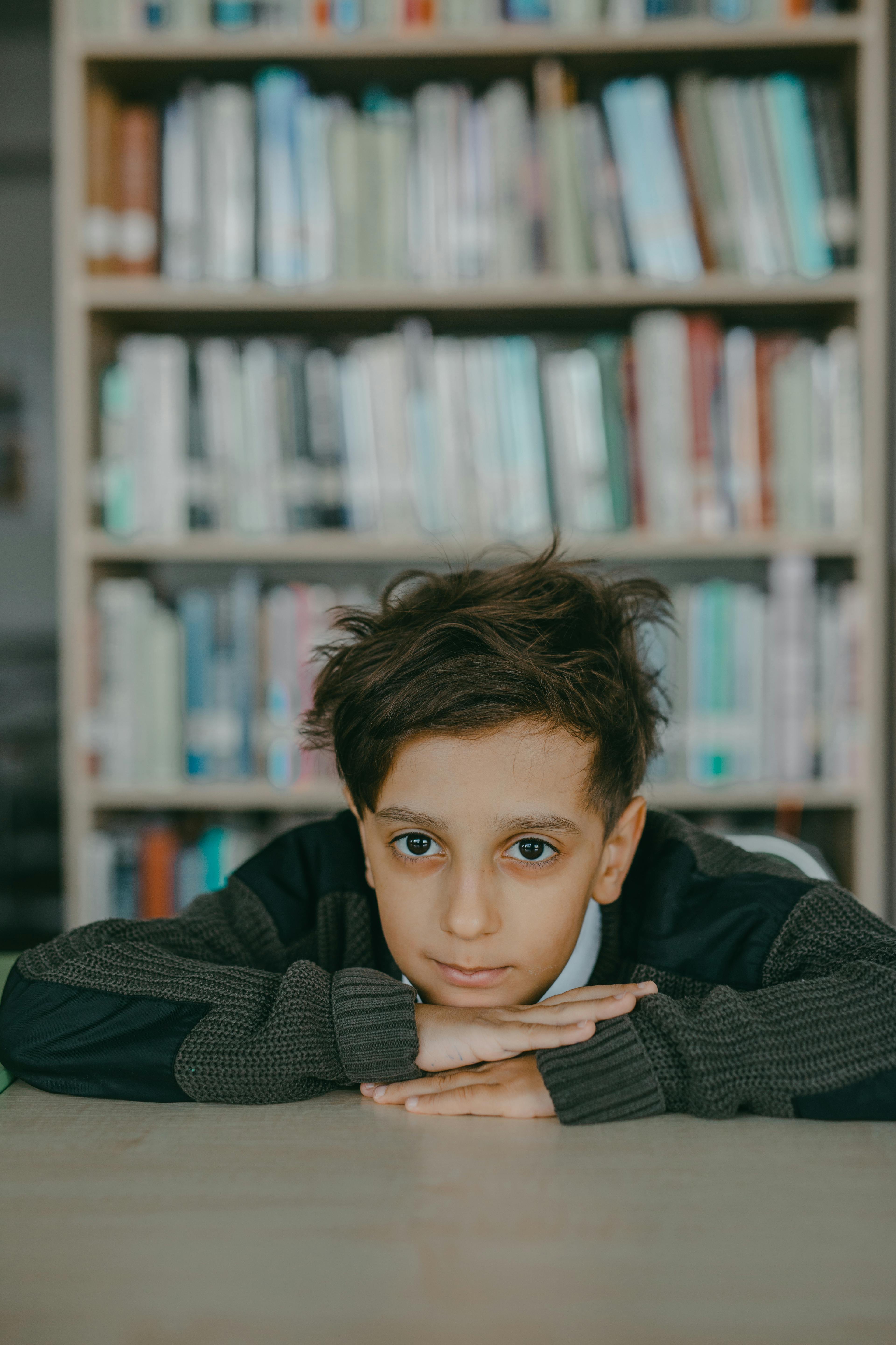Un garçon appuyé sur un bureau | Source : Pexels