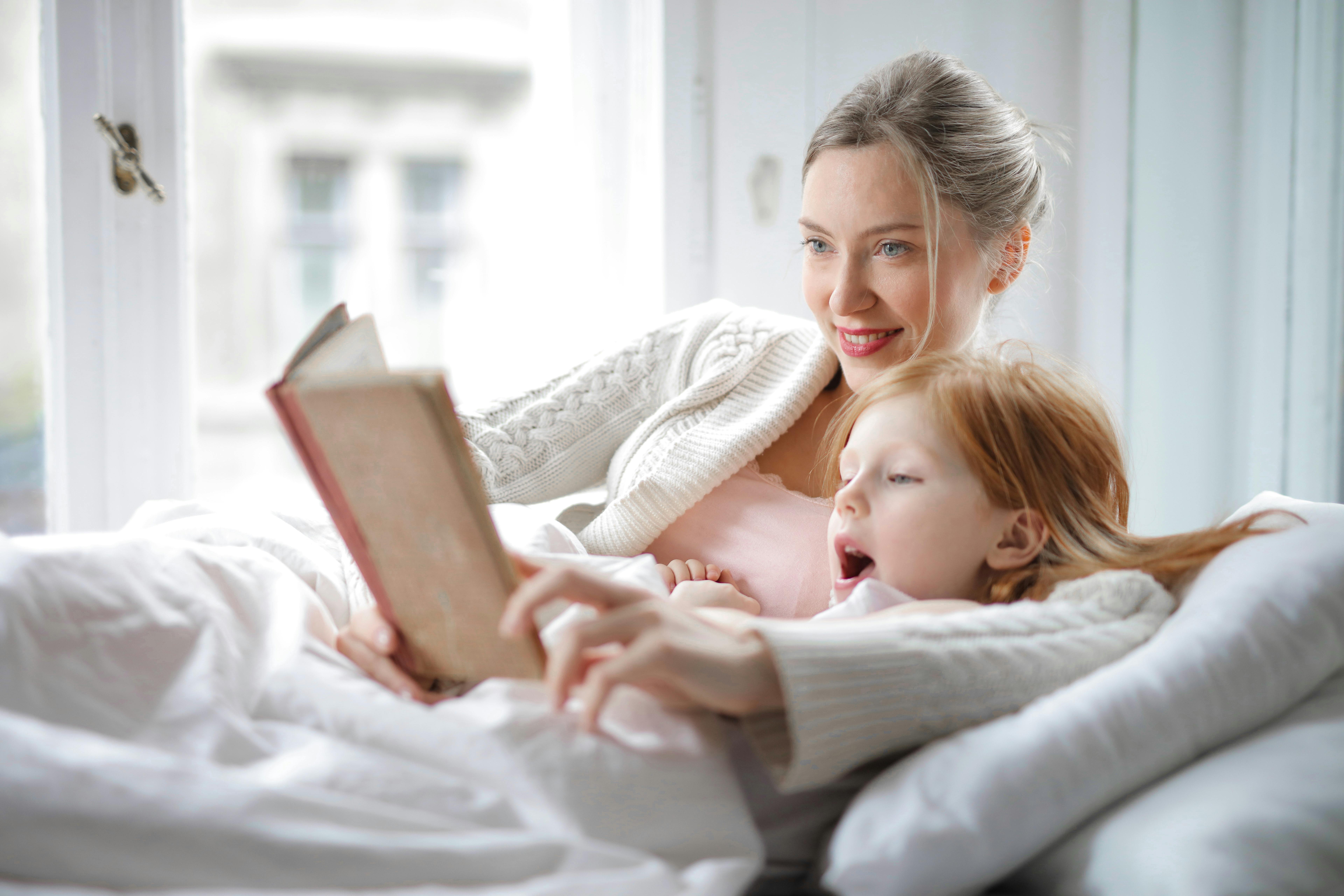 Une mère bordant sa fille dans son lit | Source : Pexels
