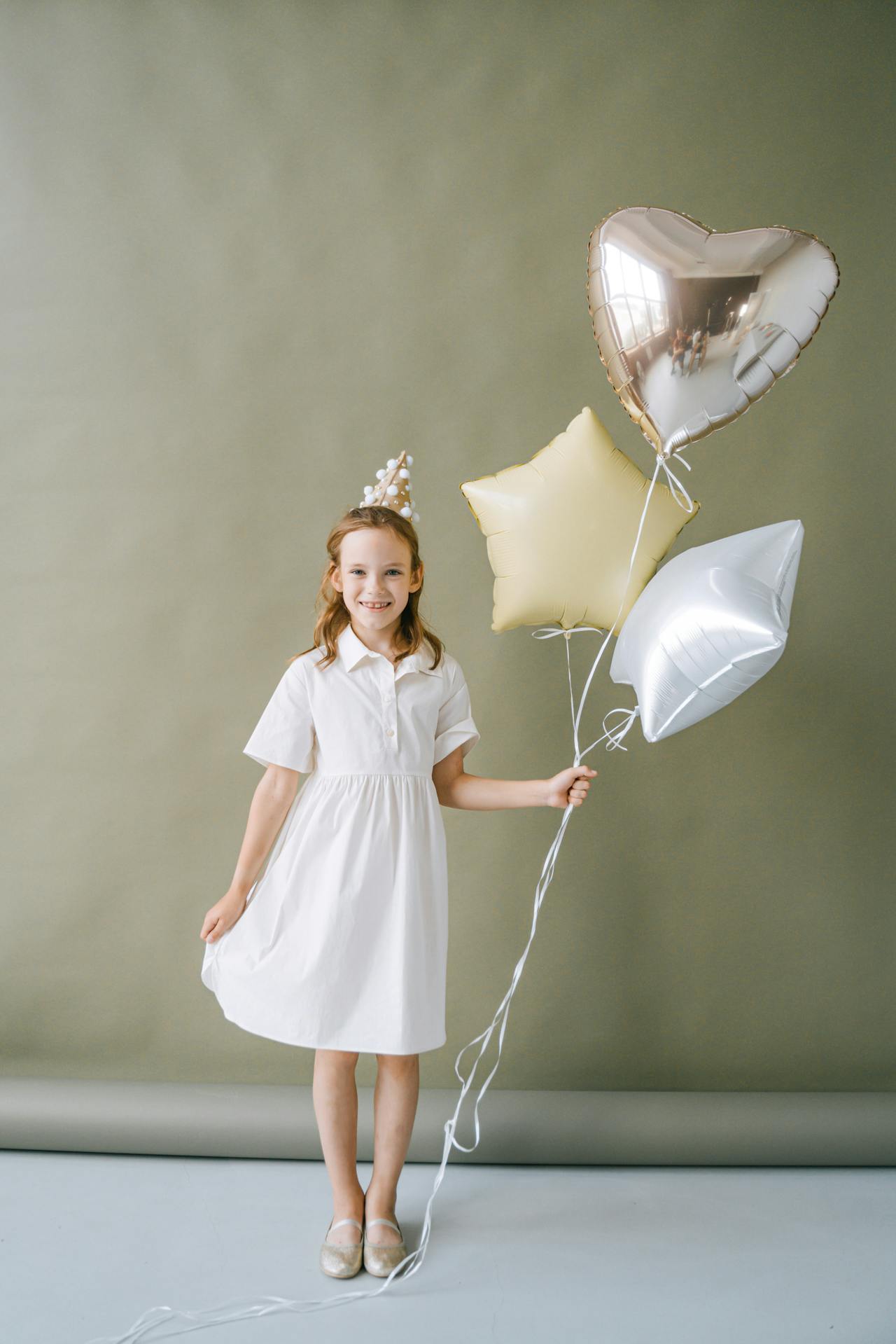 Une jeune fille ravie tenant des ballons | Source : Pexels