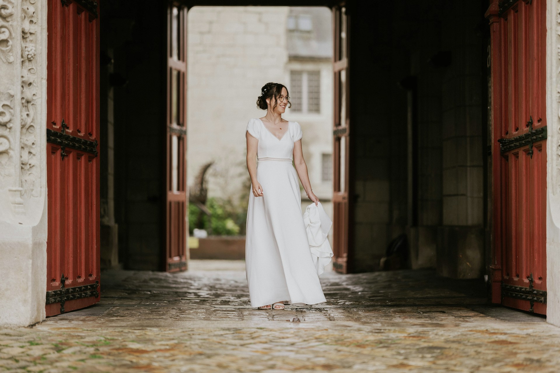 Une mariée debout près d'une porte sourit à quelqu'un | Source : Unsplash
