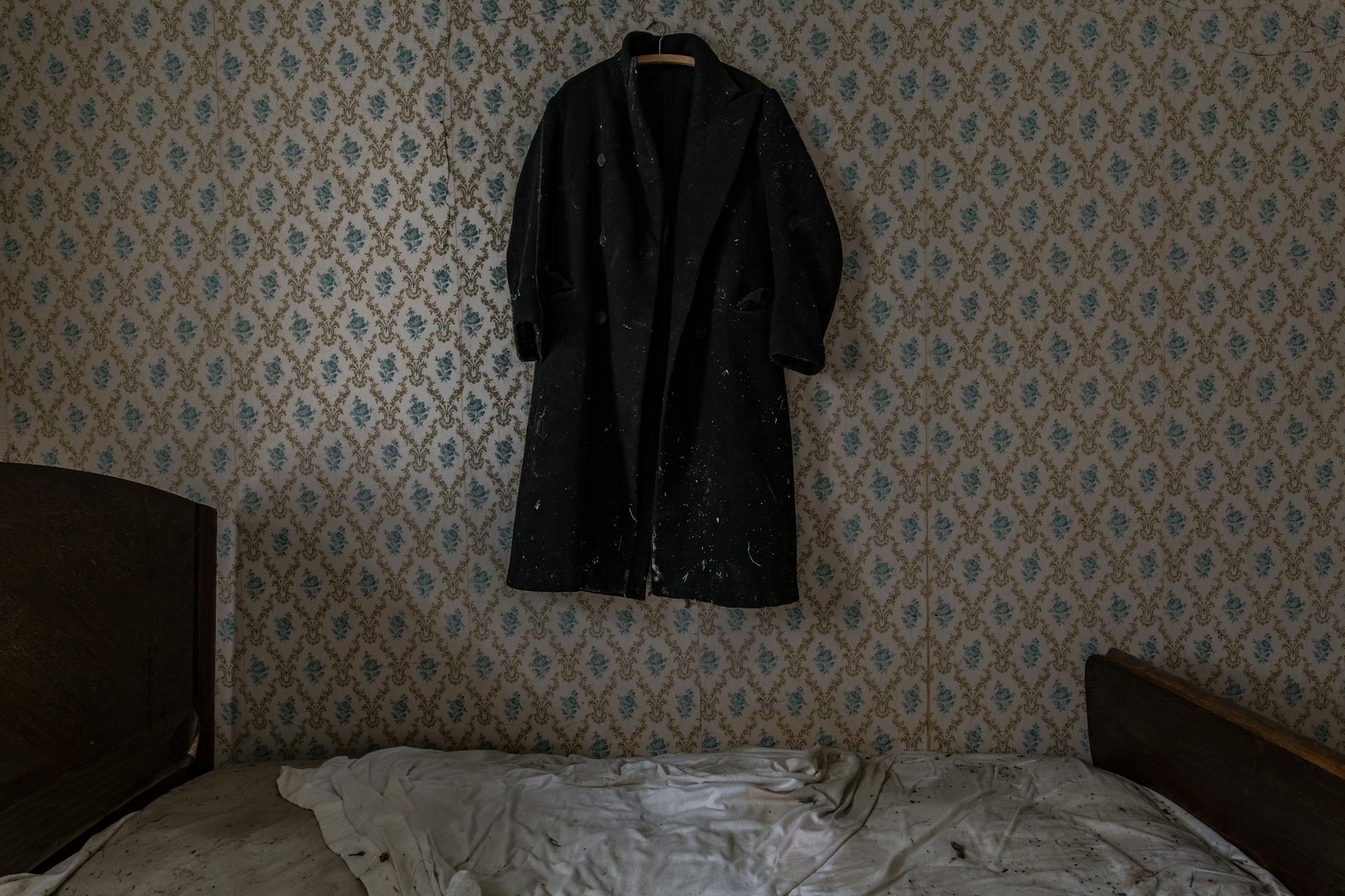 Un matelas d'apparence ancienne dans une pièce avec une veste accrochée au mur | Source : Pexels