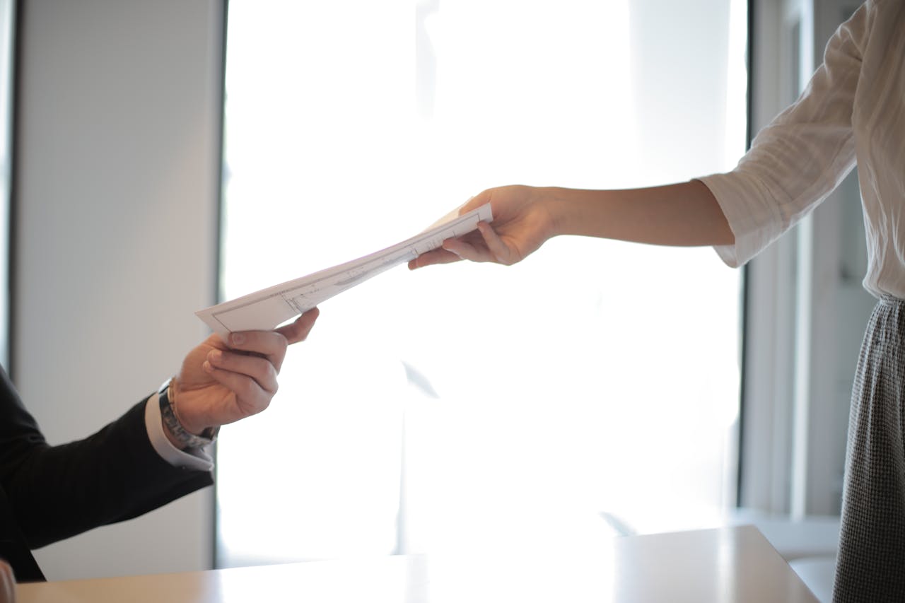 Un homme qui remet des papiers | Source : Pexels