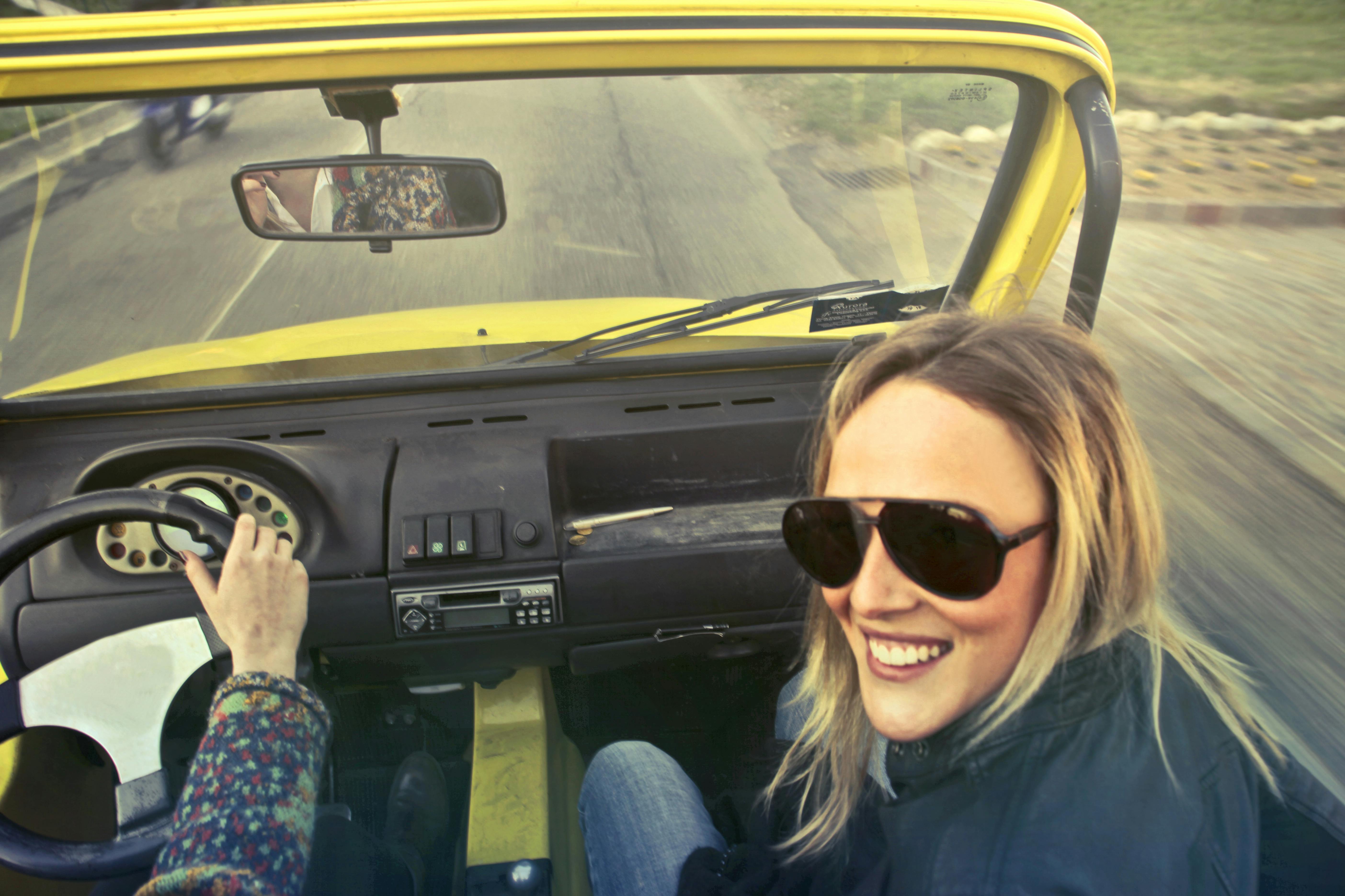 Une femme qui rit dans une voiture | Source : Pexels