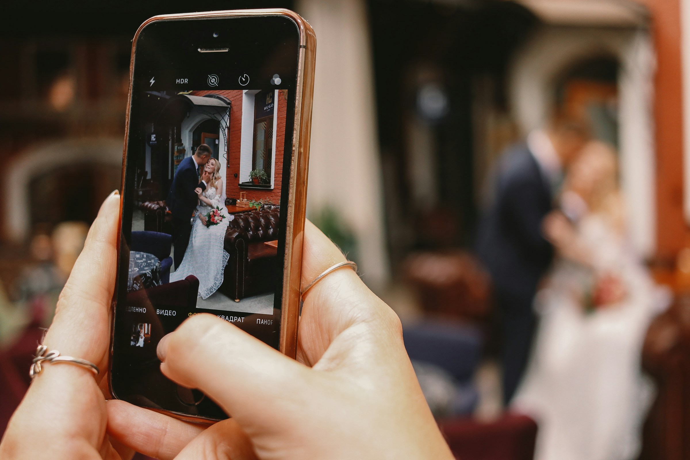 Une personne cliquant sur la photo d'un couple de mariés sur son téléphone | Source : Unsplash