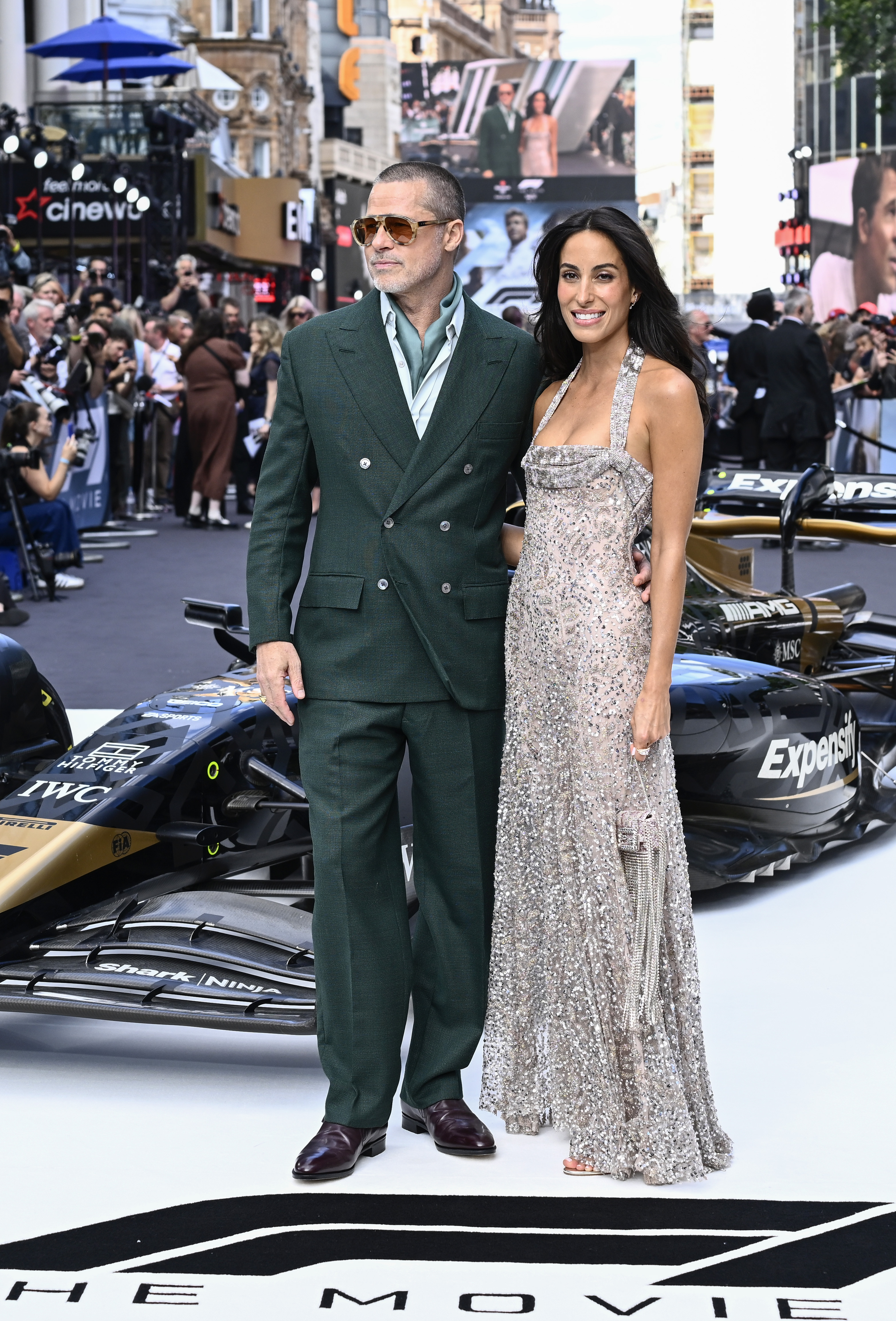 Brad Pitt et Ines de Ramon posent devant une voiture de course F1 lors de la première de "F1 : The Movie" à Londres le 23 juin 2025 | Source : Getty Images