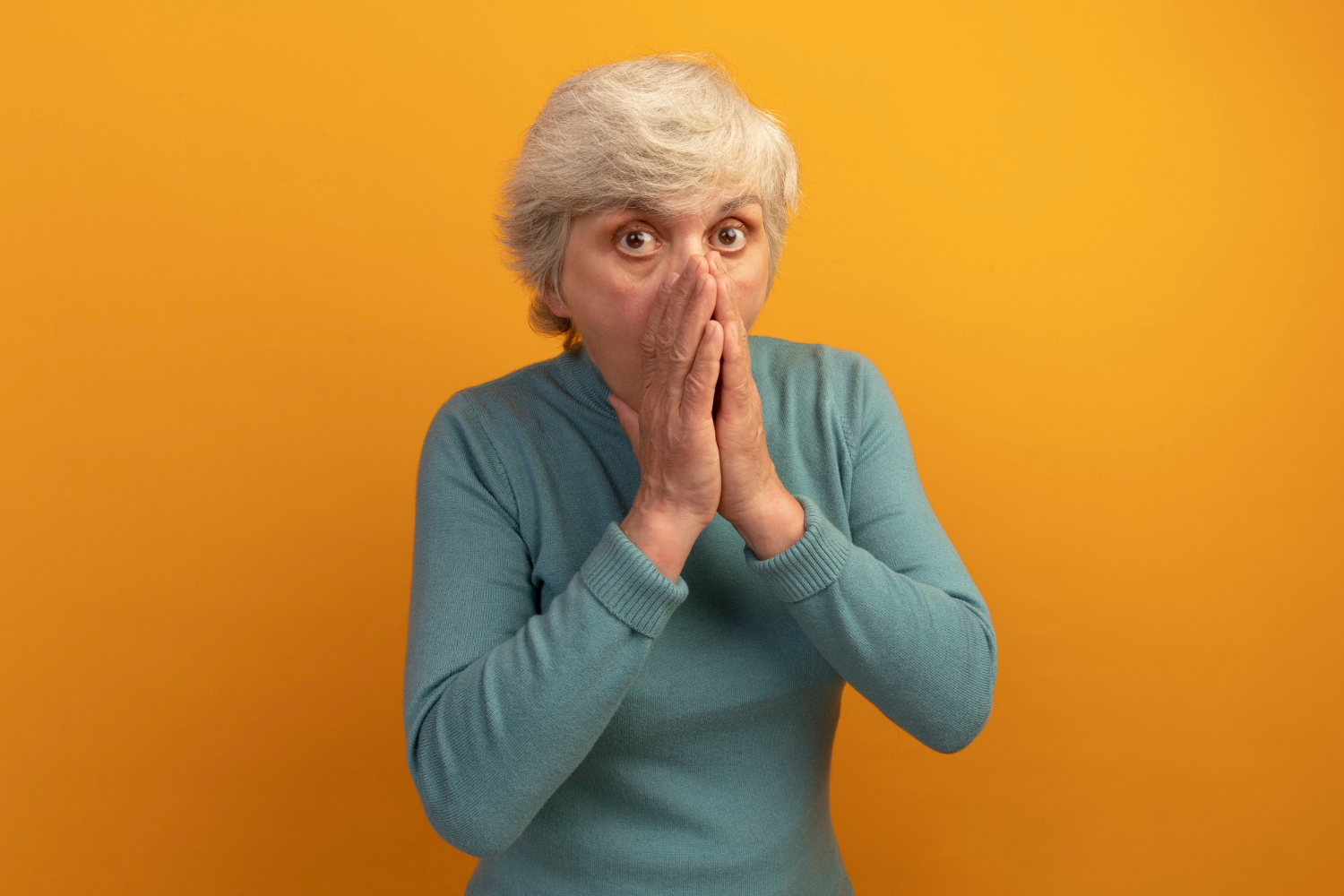 Une femme âgée choquée se couvrant la bouche | Source : Freepik