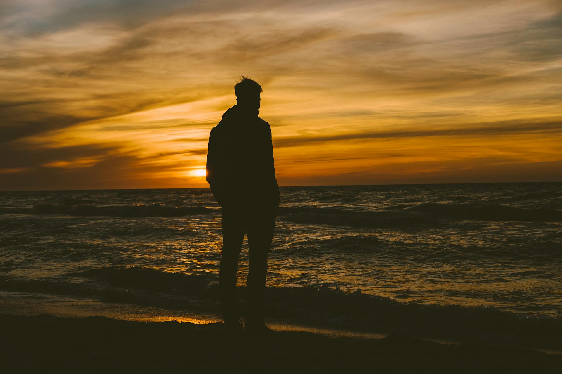 Silhouette d'un homme debout au bord de la mer | Source : Pexels
