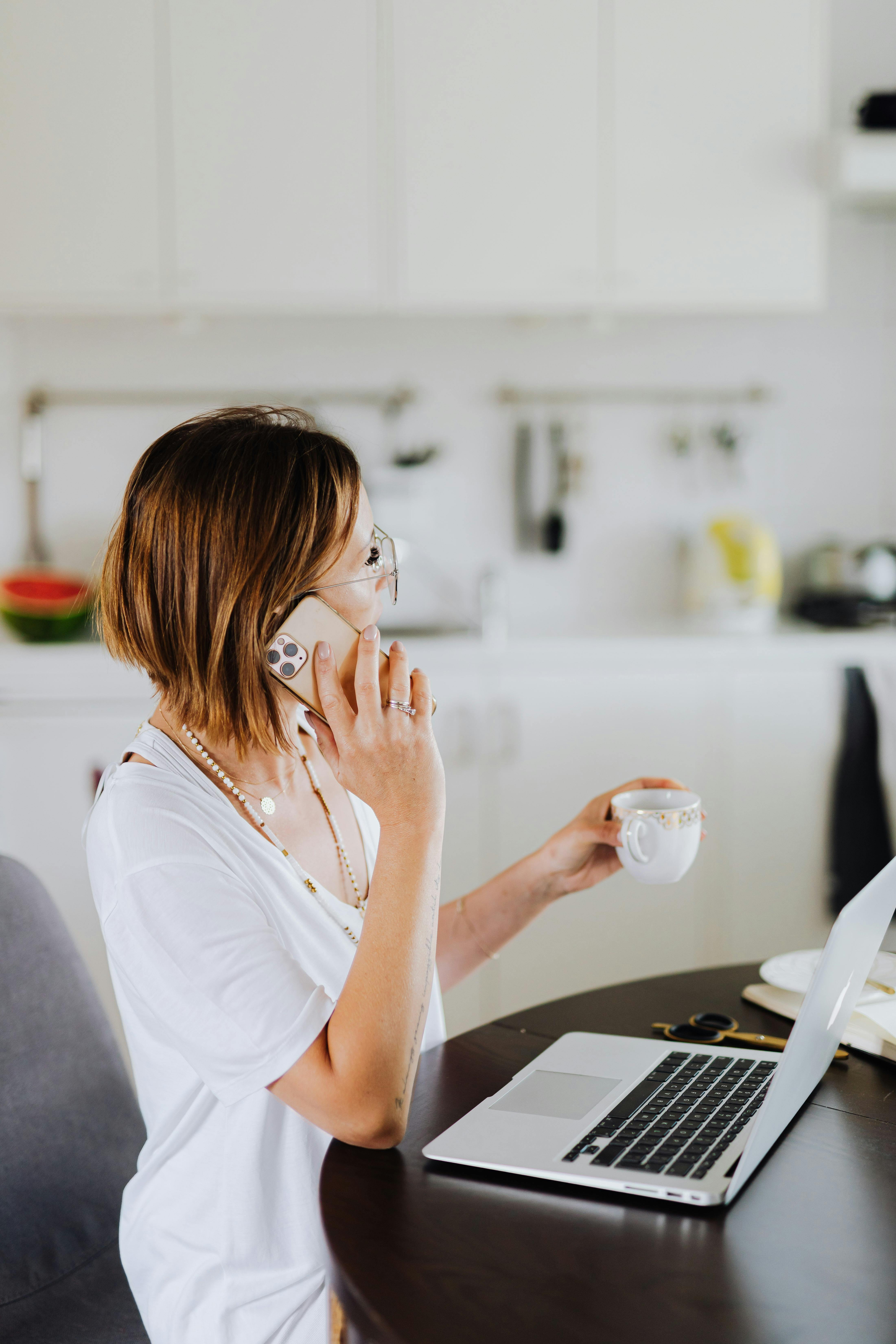 Femme parlant au téléphone tout en tenant une boisson | Source : Pexels