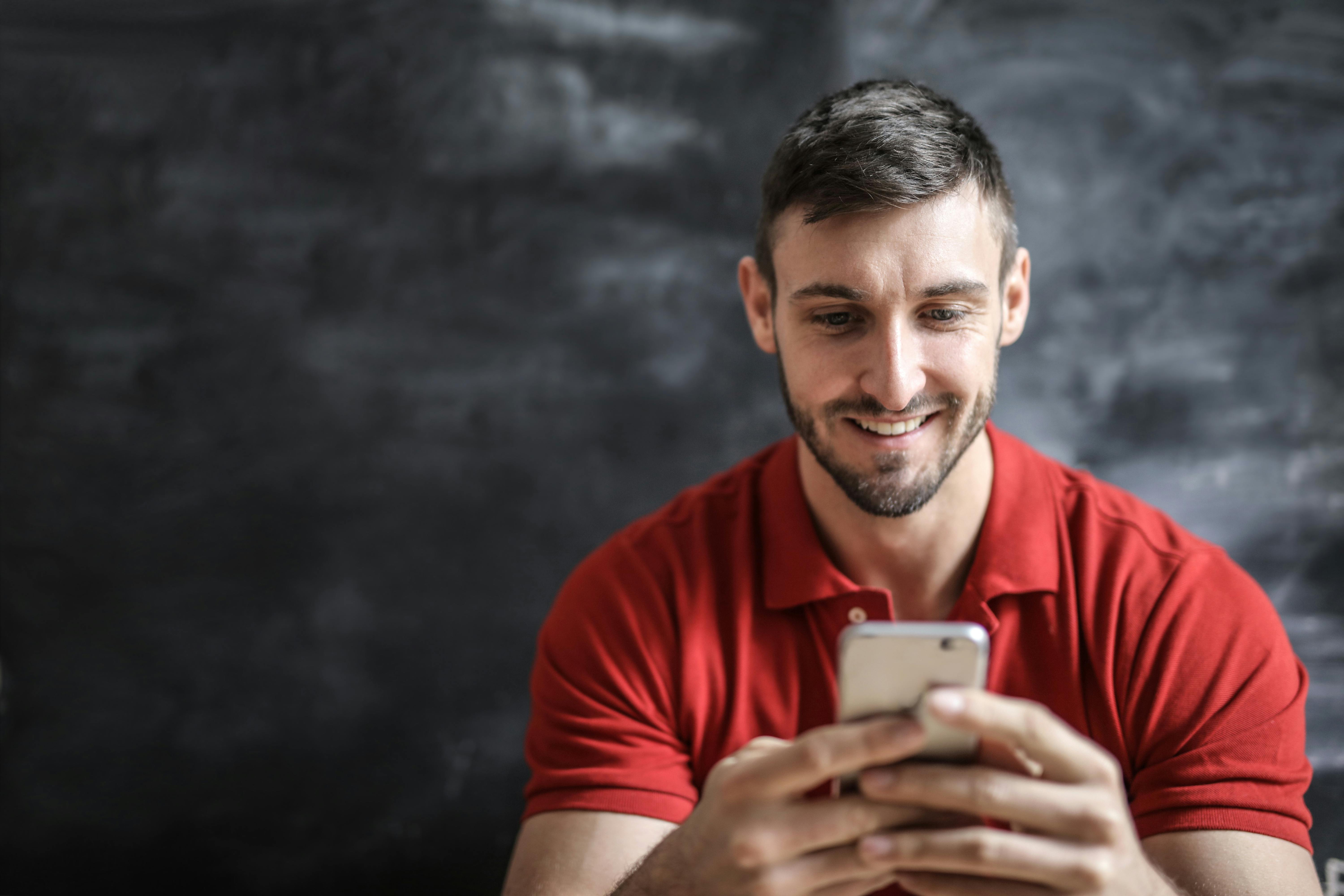 Un homme heureux utilisant son téléphone | Source : Pexels