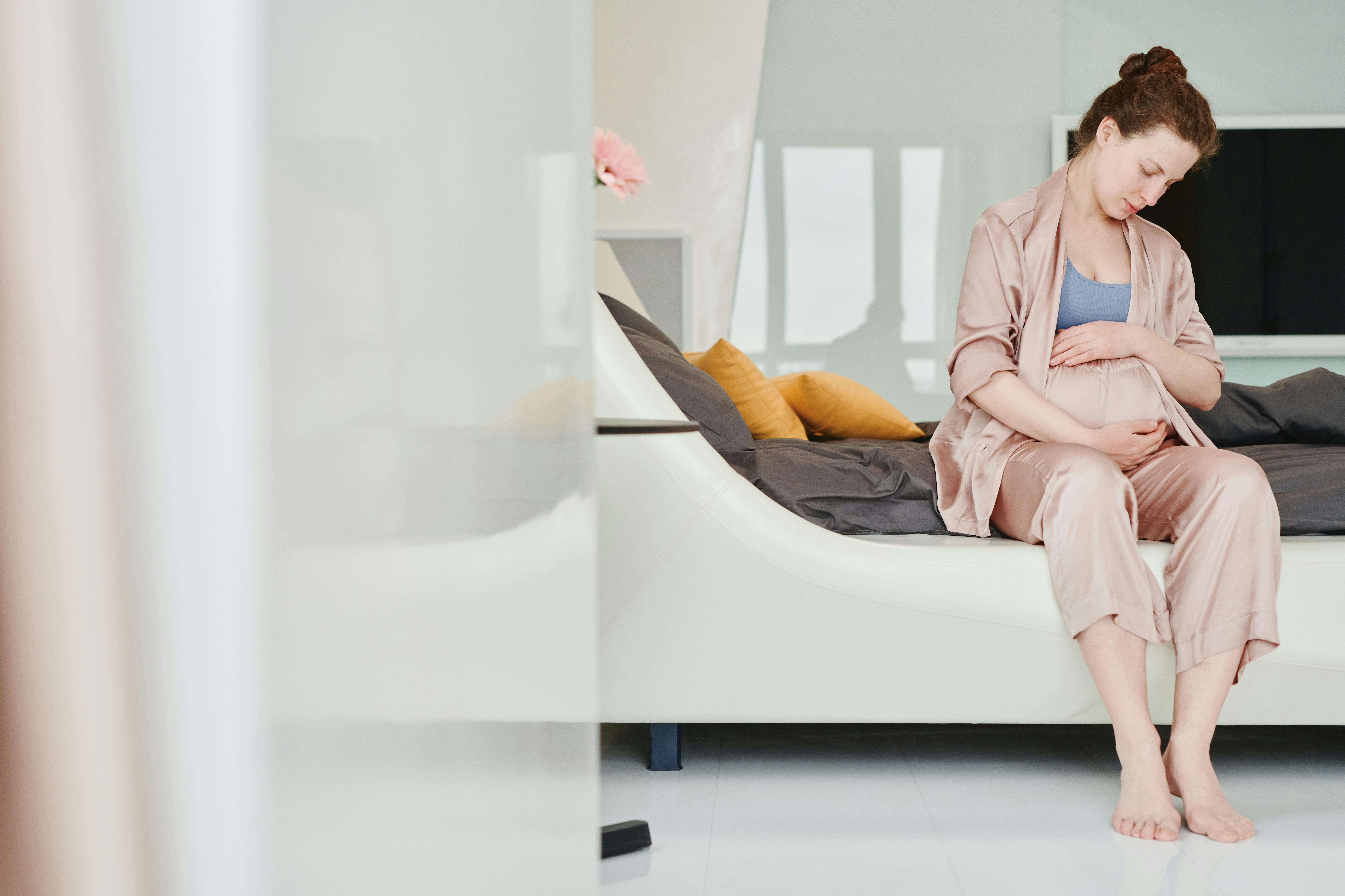 Une femme assise et berçant son ventre de femme enceinte | Source : Pexels