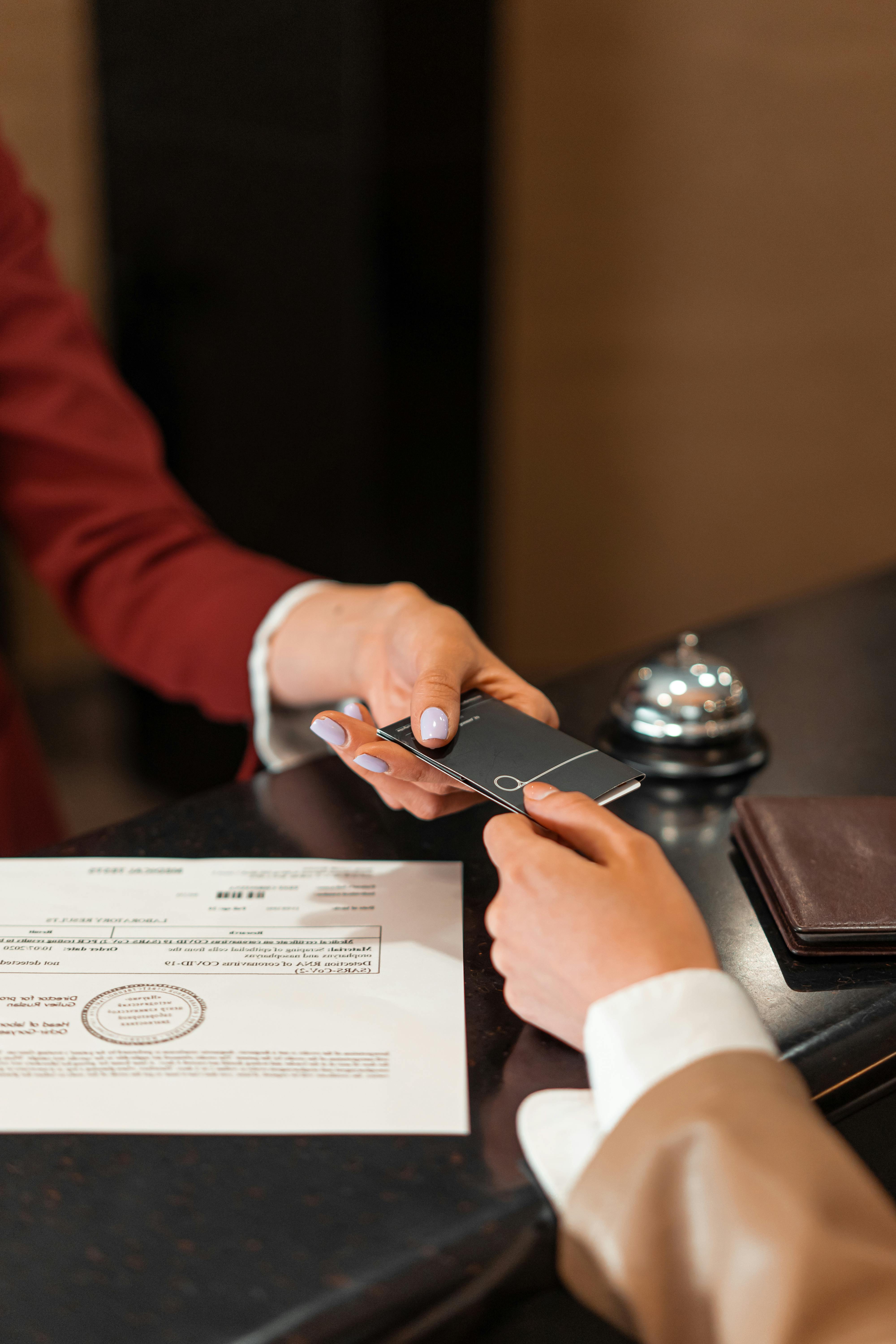 Une femme reçoit une carte-clé à la réception de l'hôtel | Source : Pexels