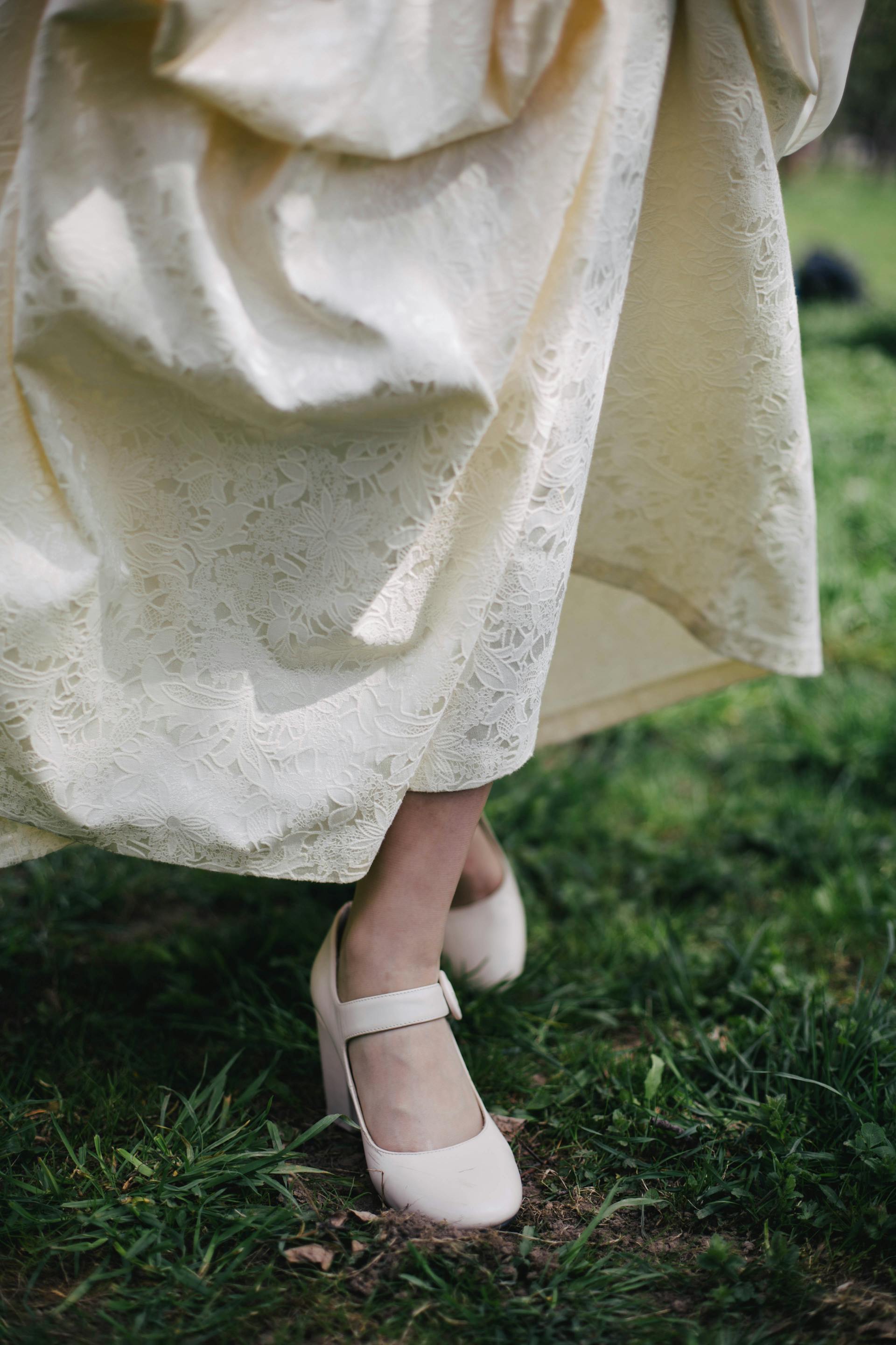 Une personne vêtue d'une robe de couleur crème marchant dans l'herbe | Source : Pexels