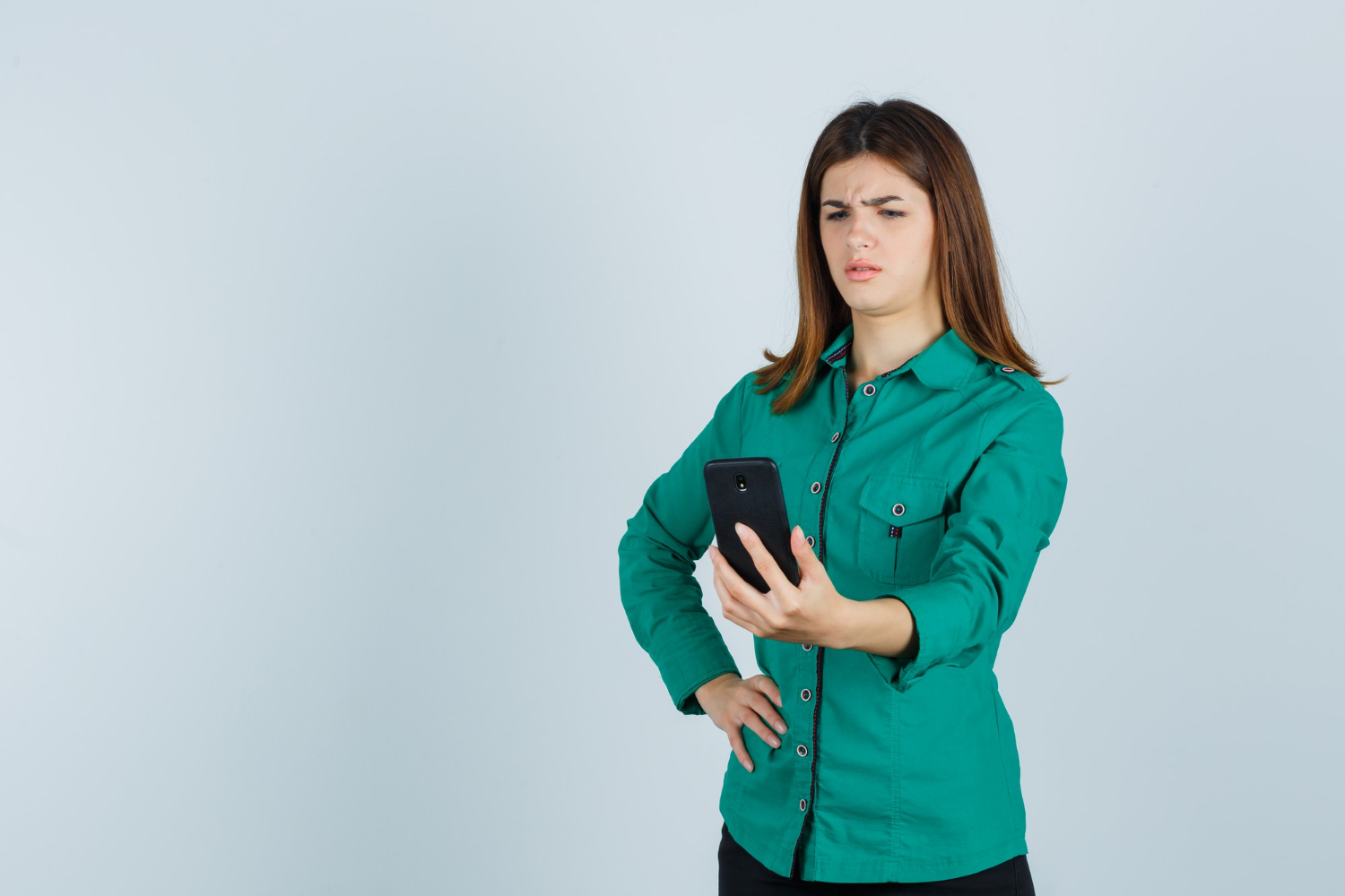 Une femme stupéfaite fixant son téléphone | Source : Freepik