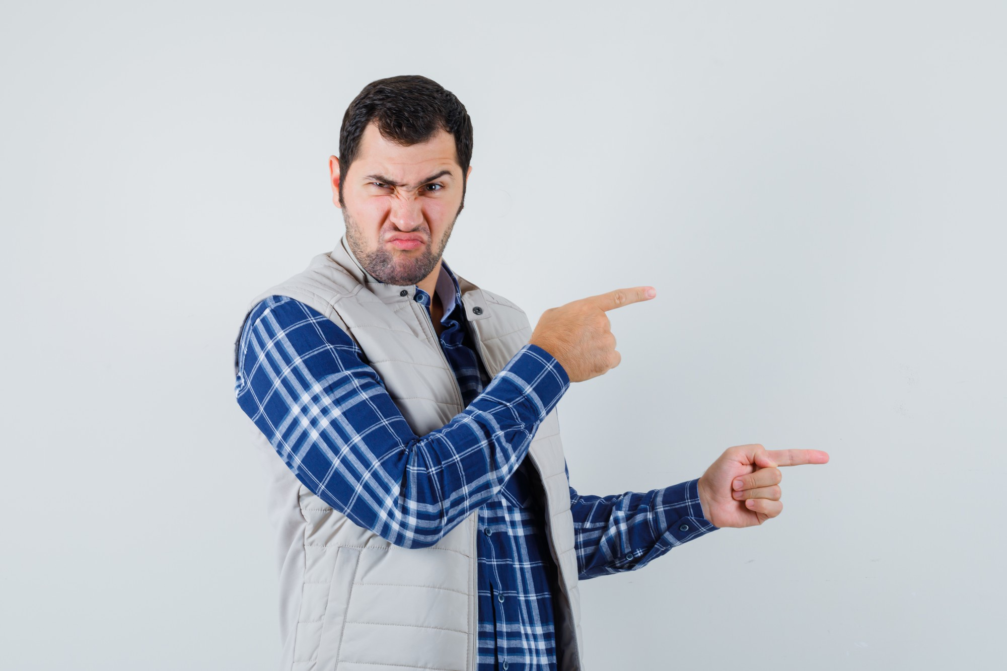 Un homme contrarié montre la sortie à quelqu'un | Source : Freepik