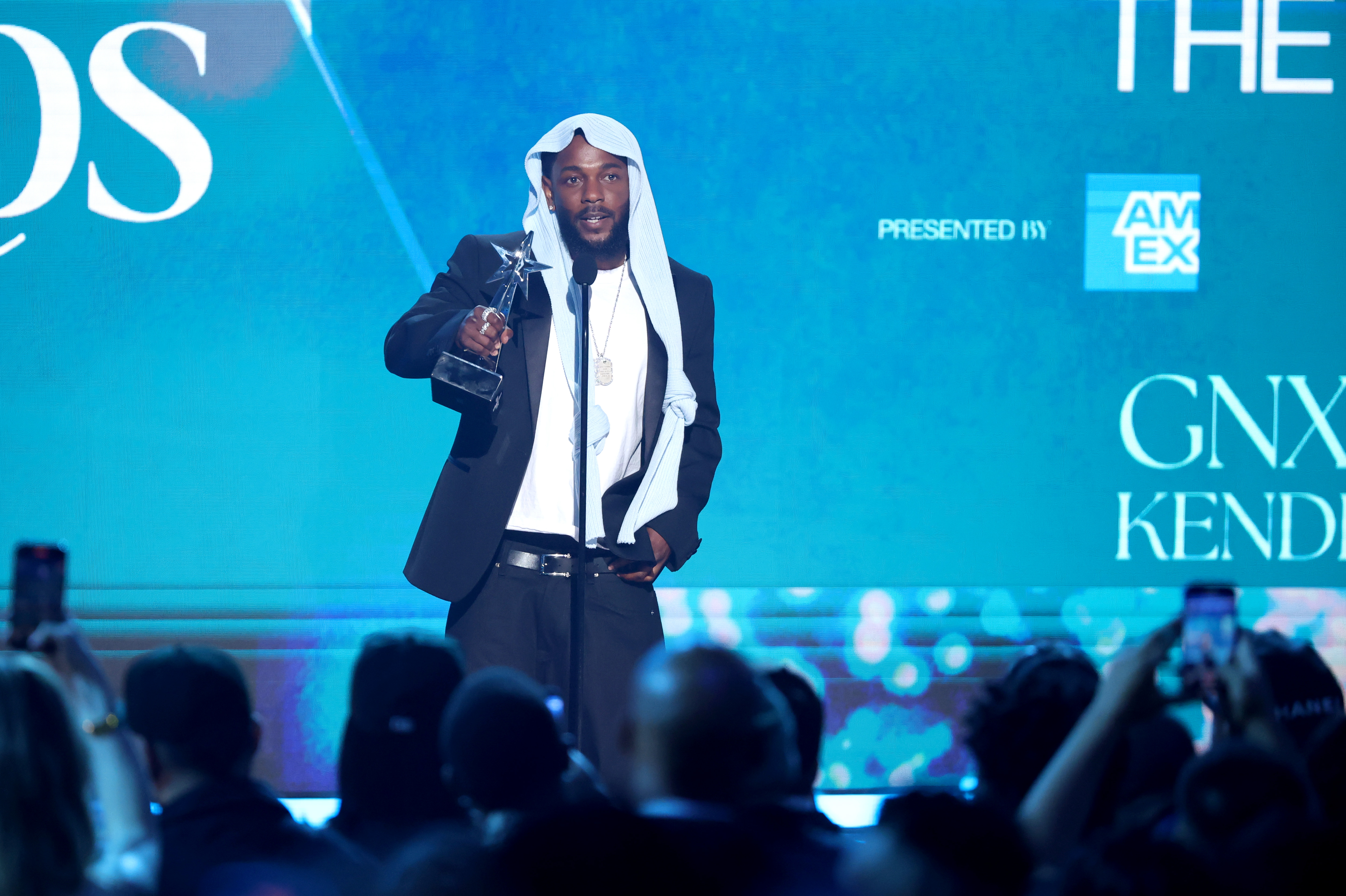 Kendrick Lamar s'adresse au public après avoir reçu un prix lors des BET Awards 2025 à Los Angeles. Vêtu d'un élégant costume noir et de sa coiffe virale, le rappeur affichait un look à la fois stylé et réfléchi sous les projecteurs.