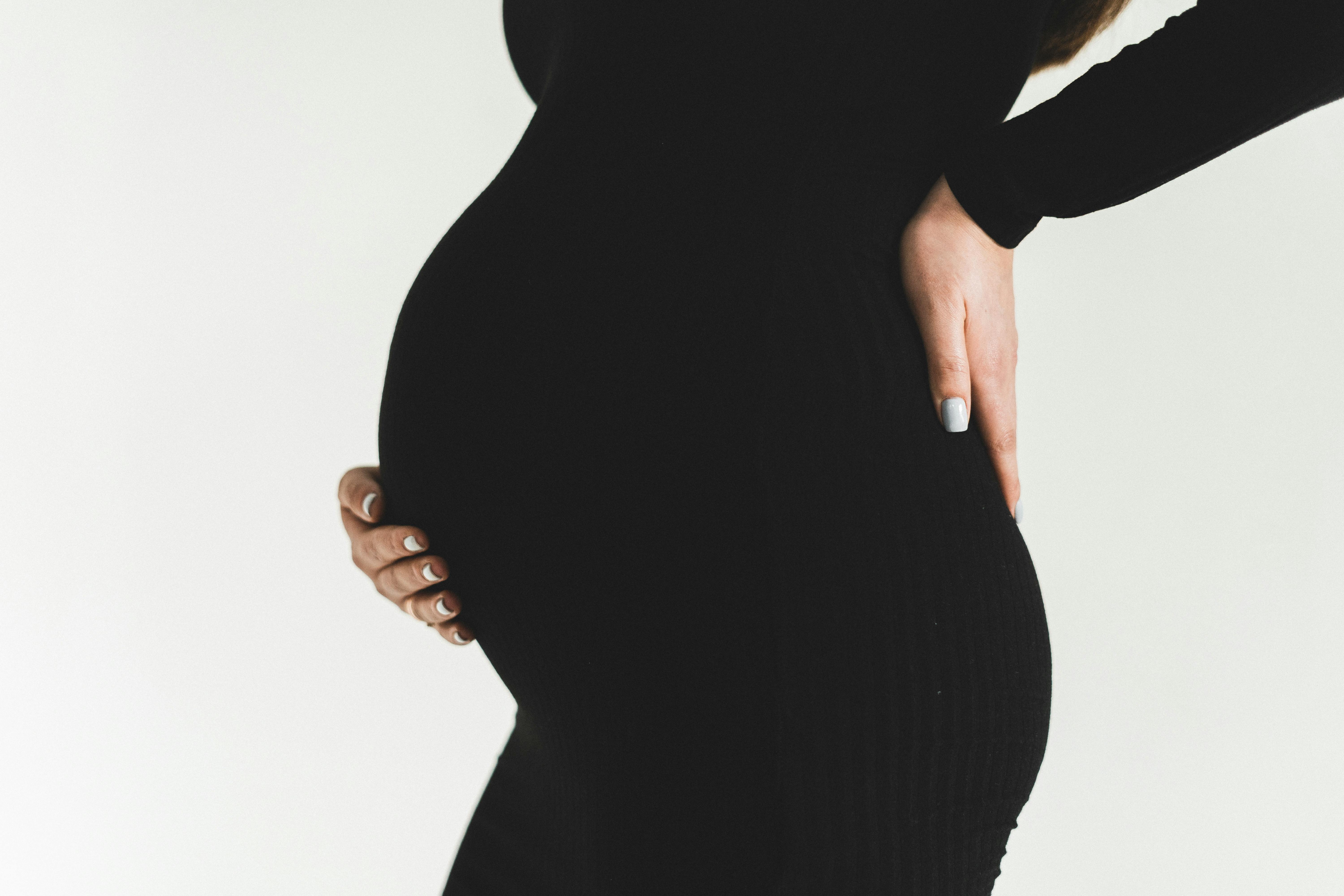 Une femme enceinte se frottant le dos | Source : Pexels