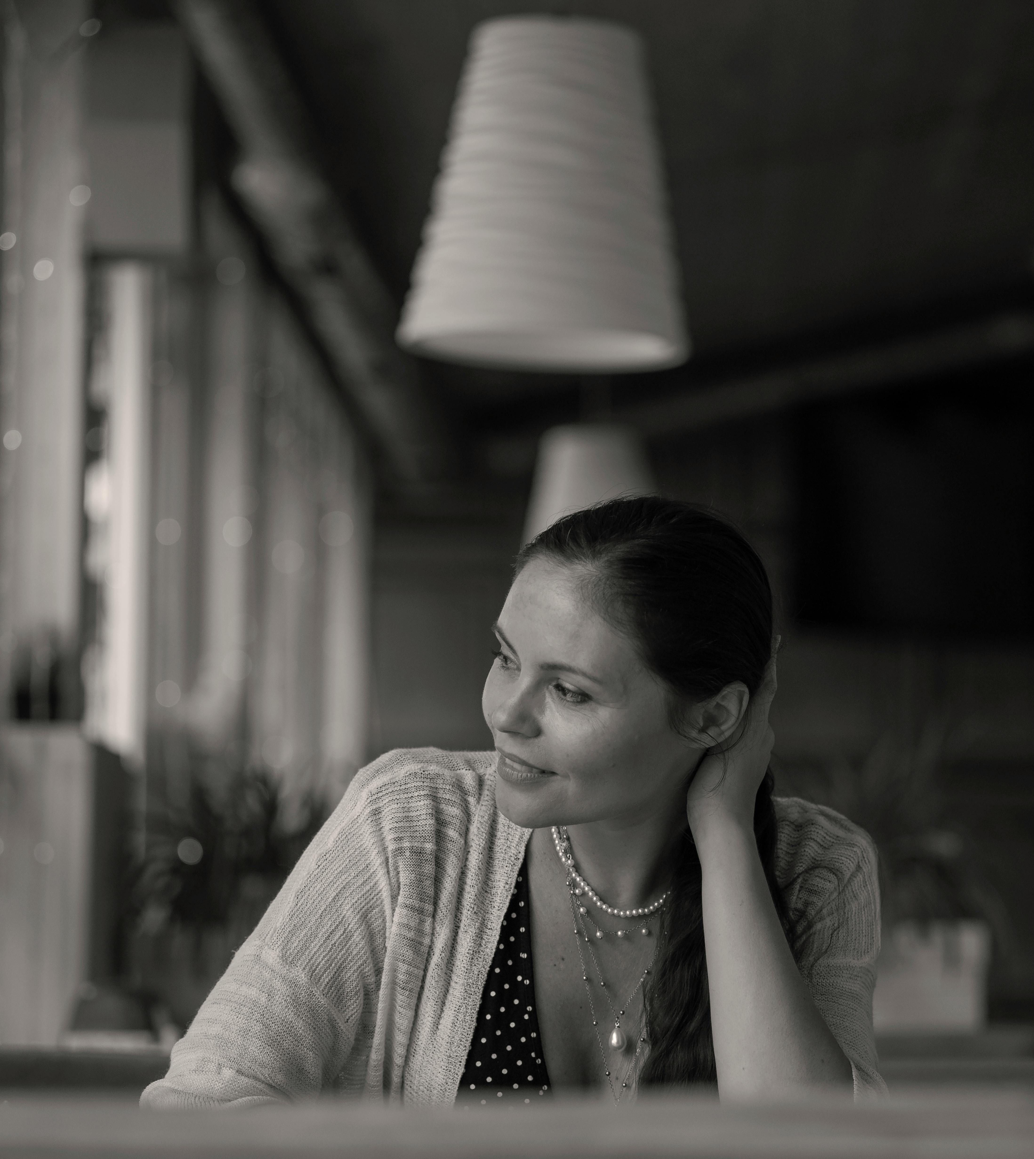 Photo en niveaux de gris d'une femme assise dans un restaurant | Source : Pexels