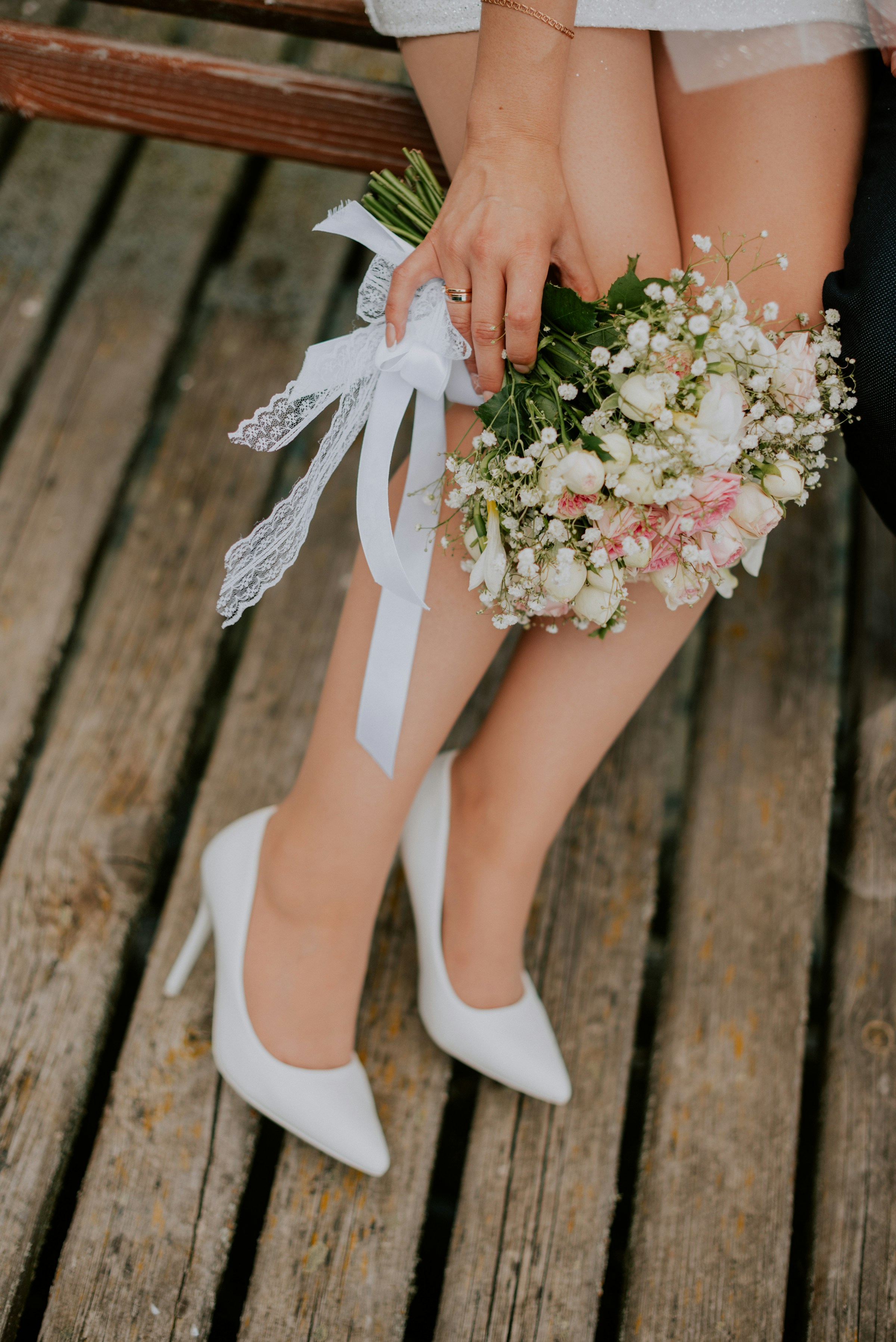 Une mariée en talons blancs tenant des fleurs | Source : Unsplash