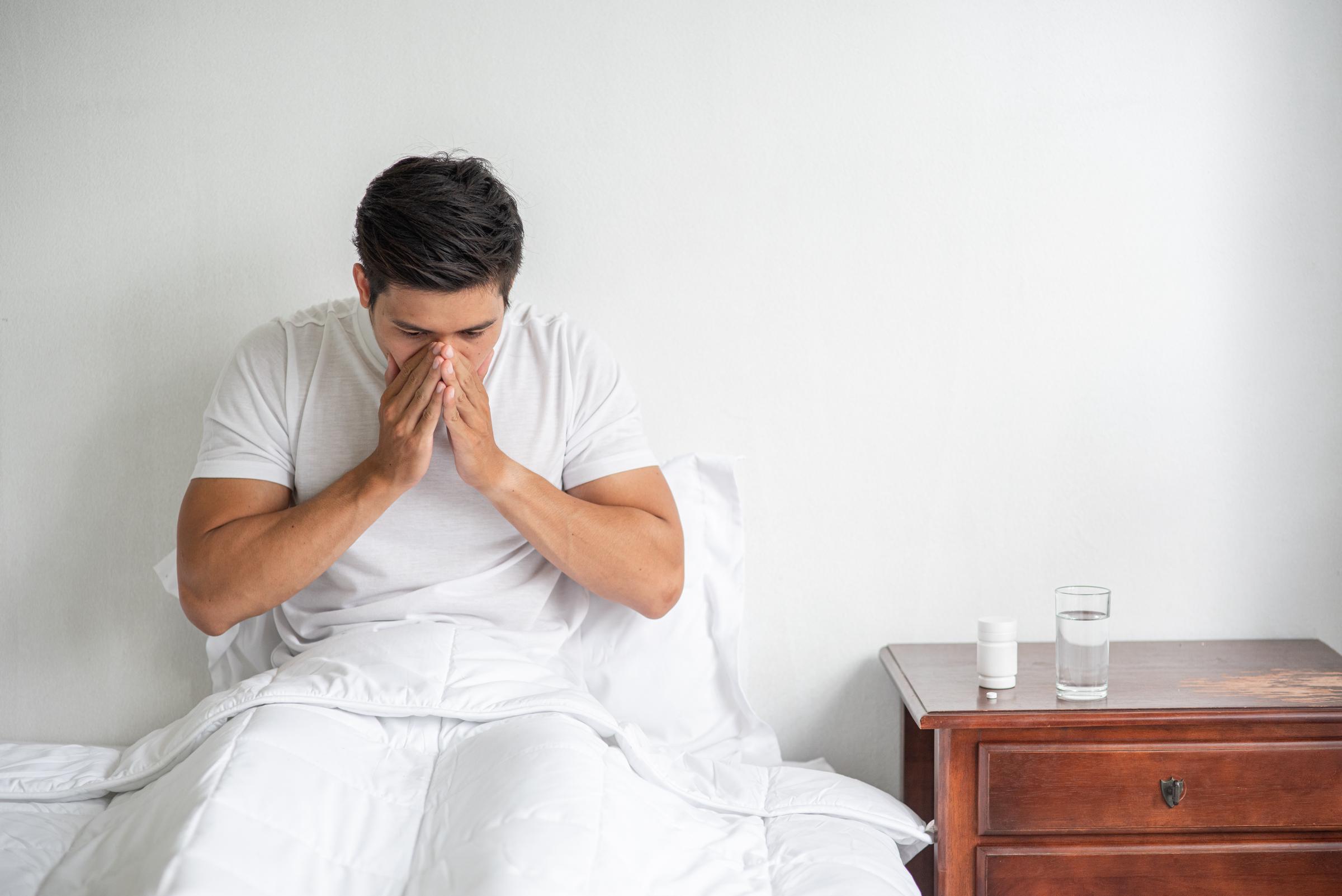 Un homme en détresse assis sur le lit | Source : Freepik