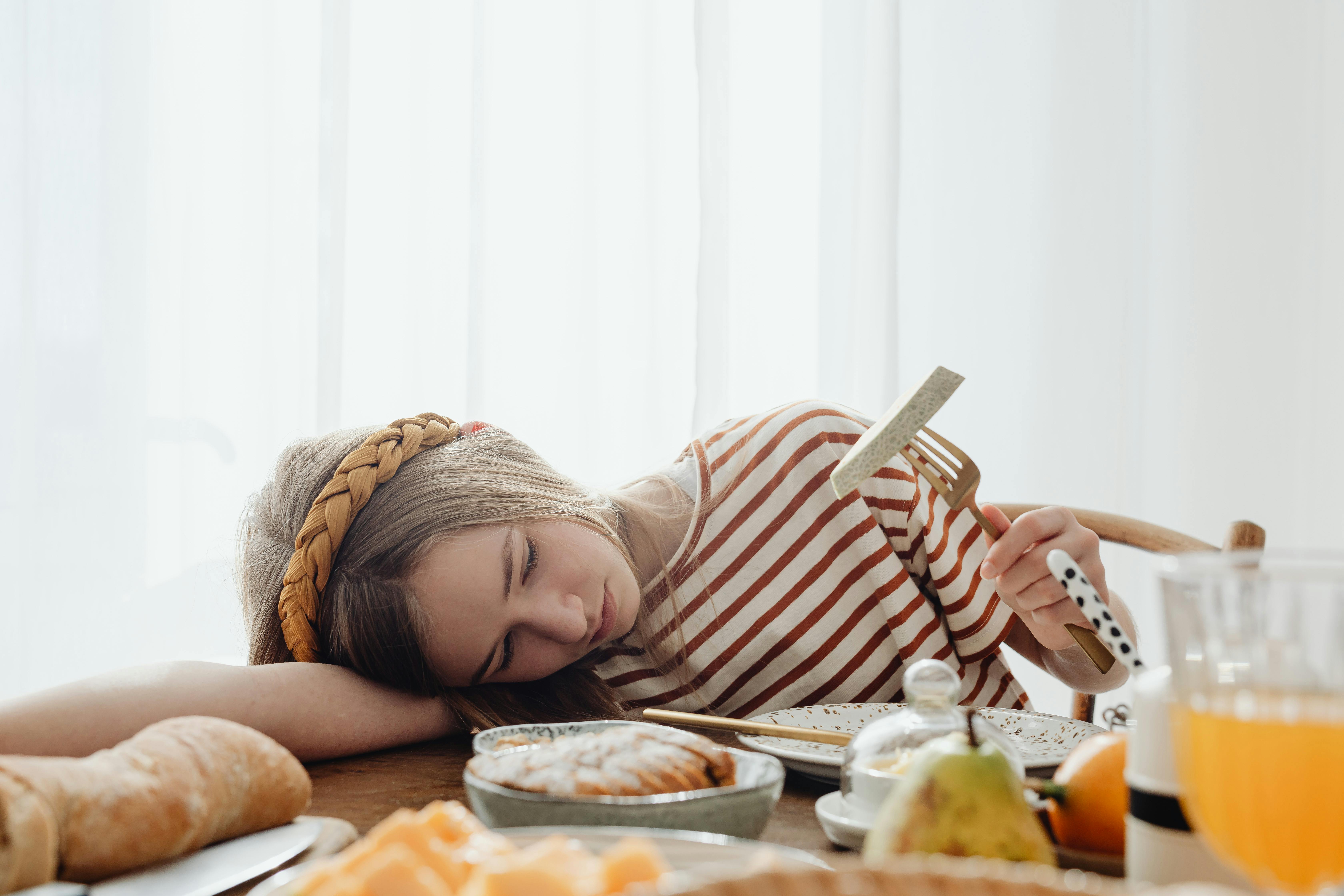 Une adolescente triste à la table du petit déjeuner | Source : Pexels