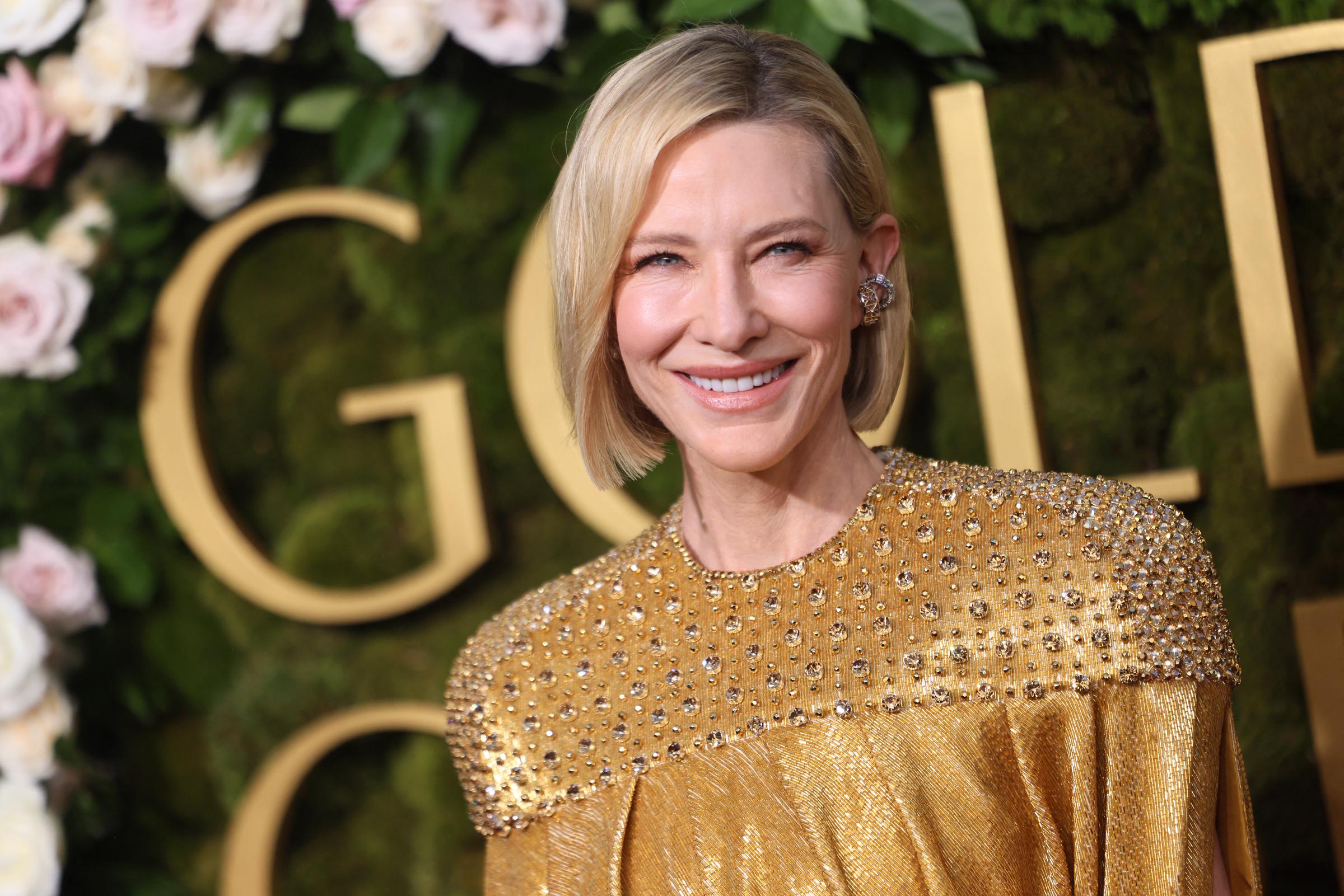 Cate Blanchett arrive aux Golden Globes à Beverly Hills et pose devant un décor floral orné d'une grande inscription annonçant l'événement | Source : Getty Images