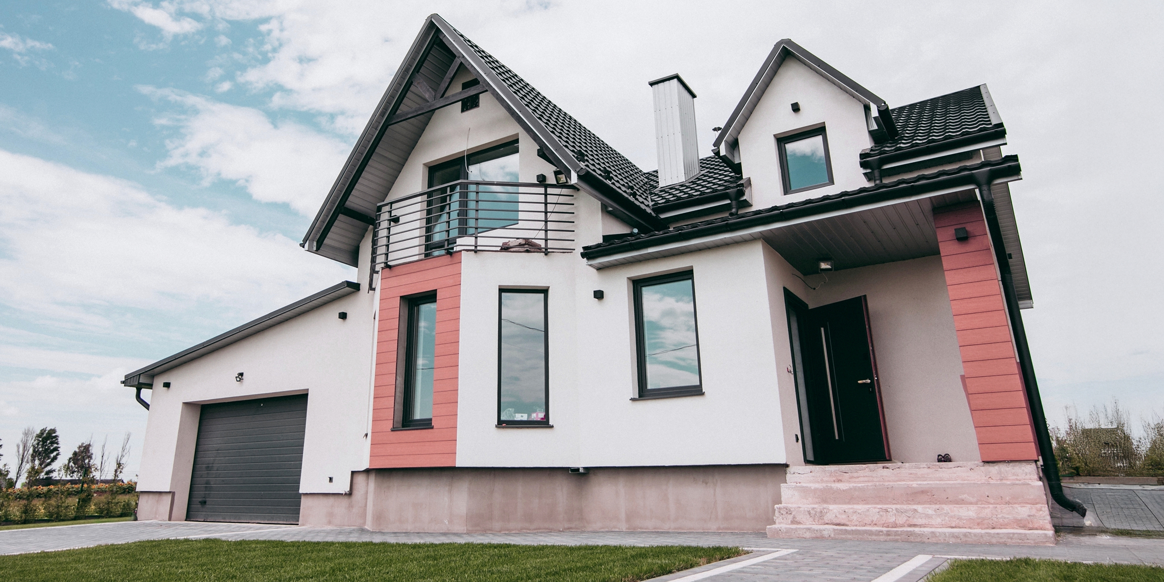 Maison de banlieue moderne posée sur un ciel partiellement nuageux | Source : Shutterstock