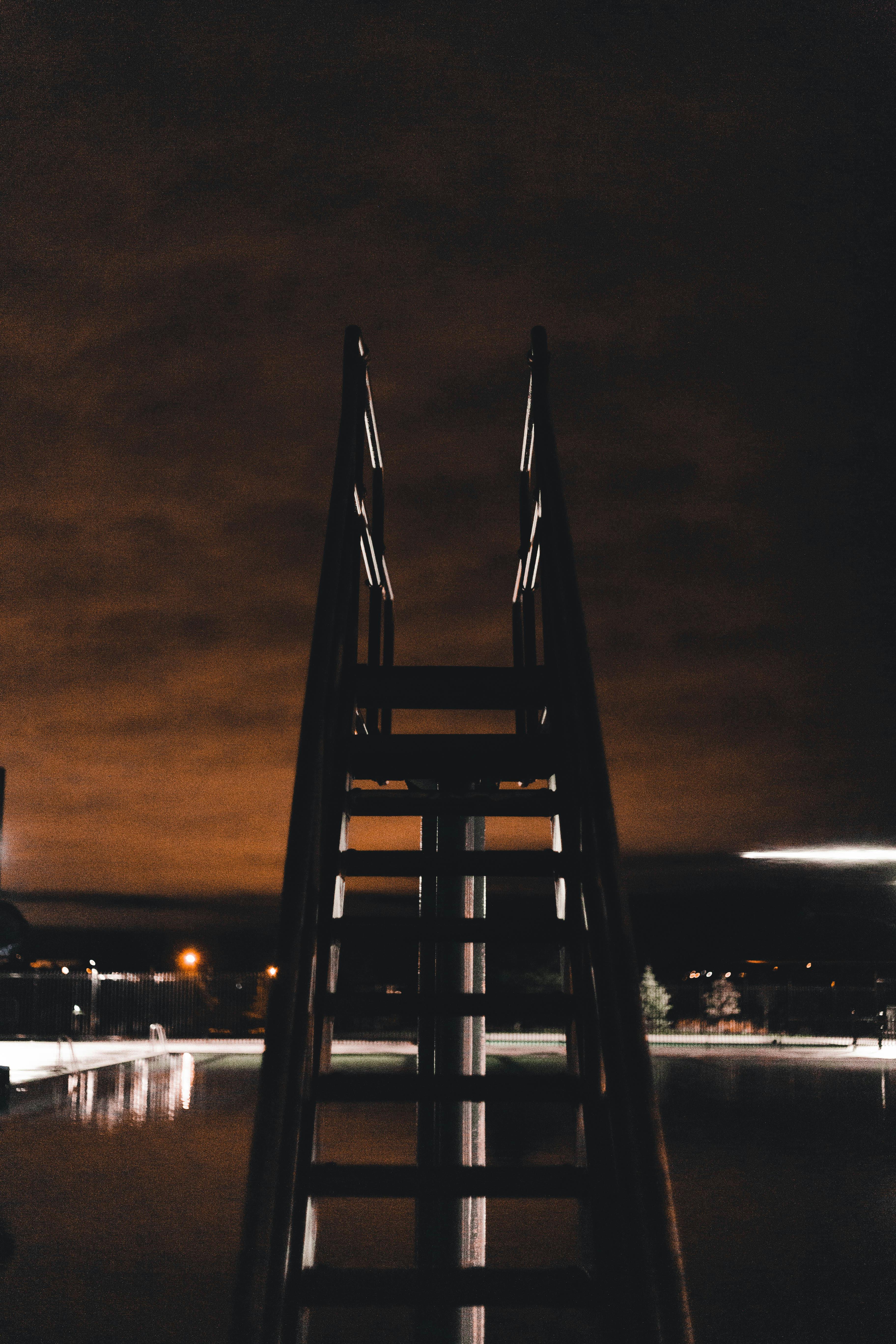 Un plongeoir dans une piscine la nuit | Source : Pexels