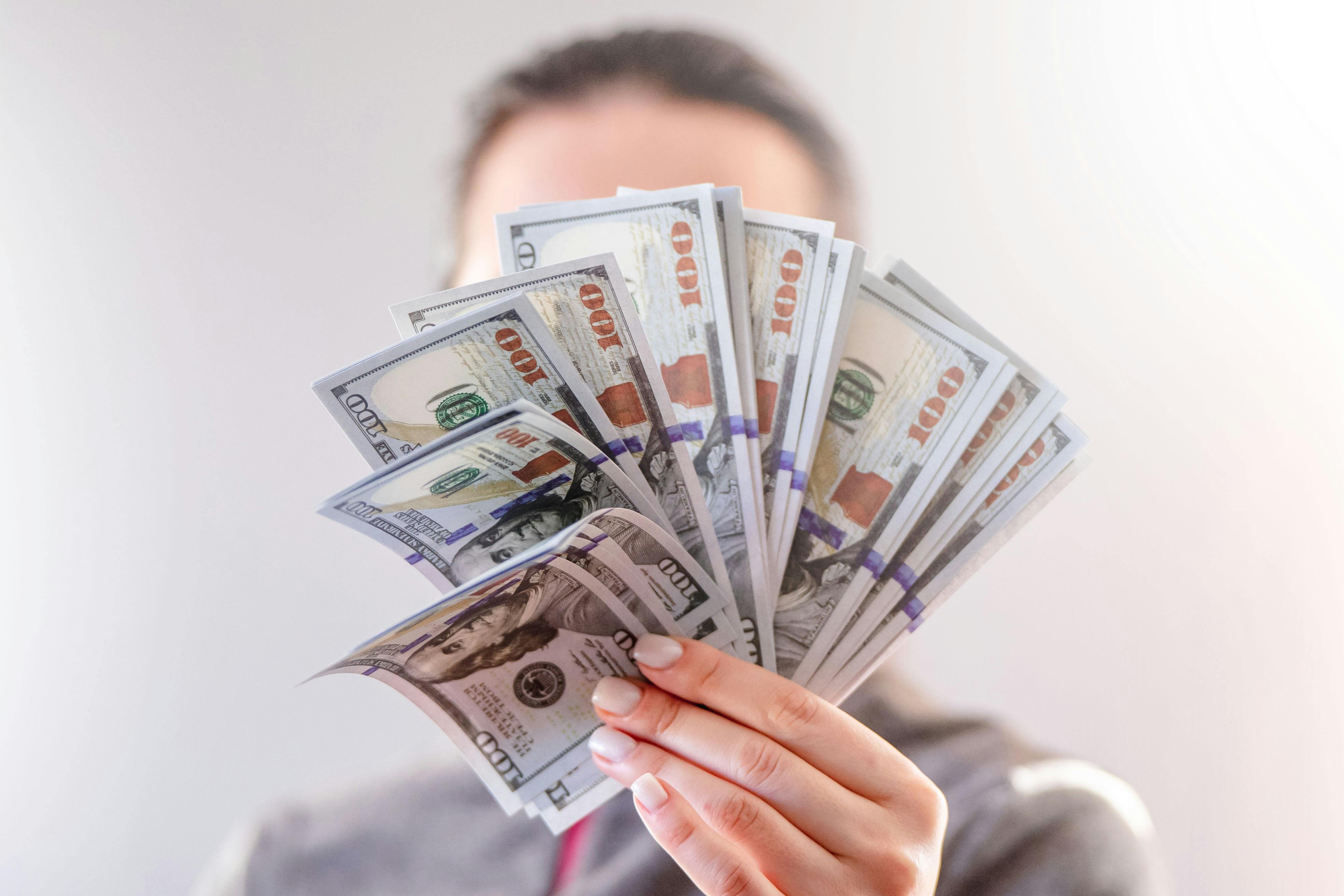Femme tenant une liasse de billets | Source : Pexels