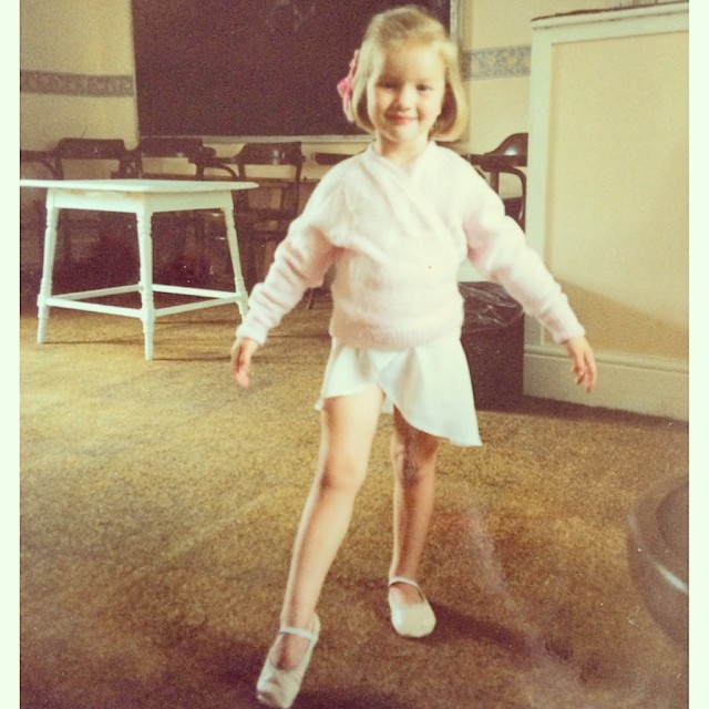 Rosie Alice Huntington-Whiteley pose sur un cliché de ballet d'enfance, souriant dans un pull pâle, une jupe et des ballerines. | Source : Instagram/rosiehw